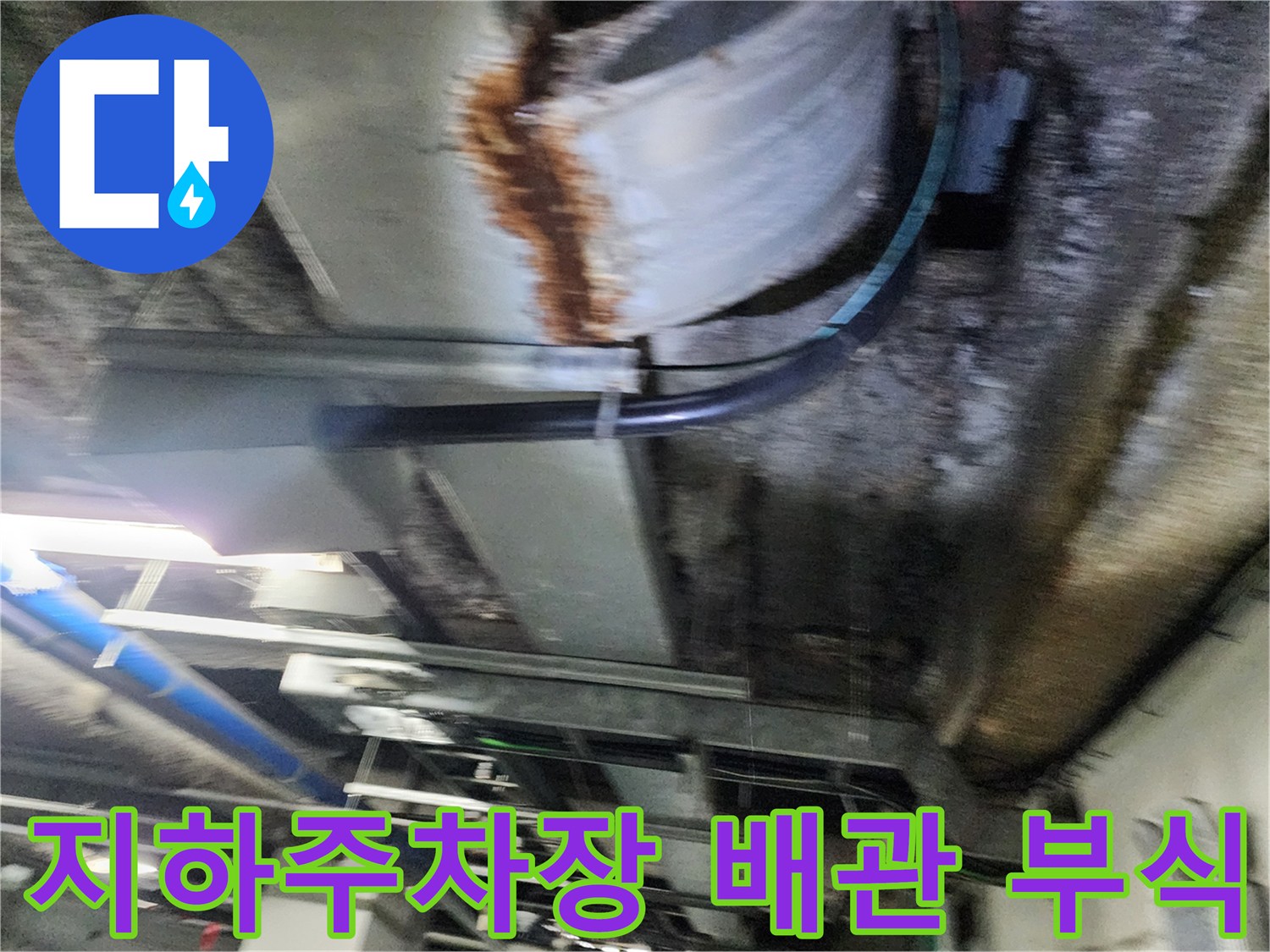 지하 주차장 천장-부식된 금속 배관과 습기 흔적