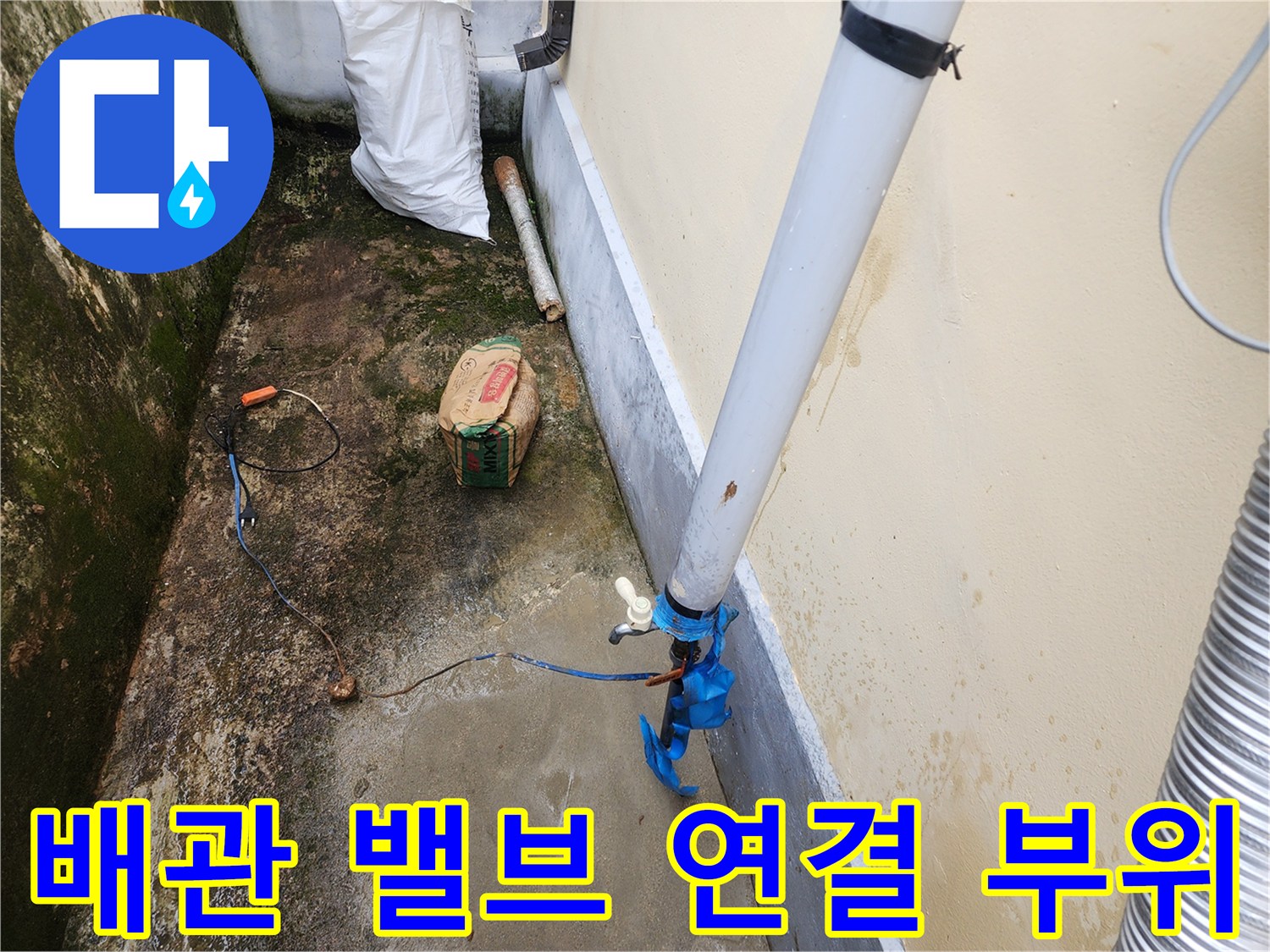 하얀색 배관 끝에 달린 파란색 밸브와 연결 장치를 보여주는 사진입니다.
