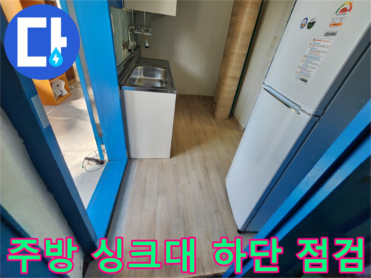 싱크대 밑 공간과 냉장고가 배치된 주방 바닥의 모습
