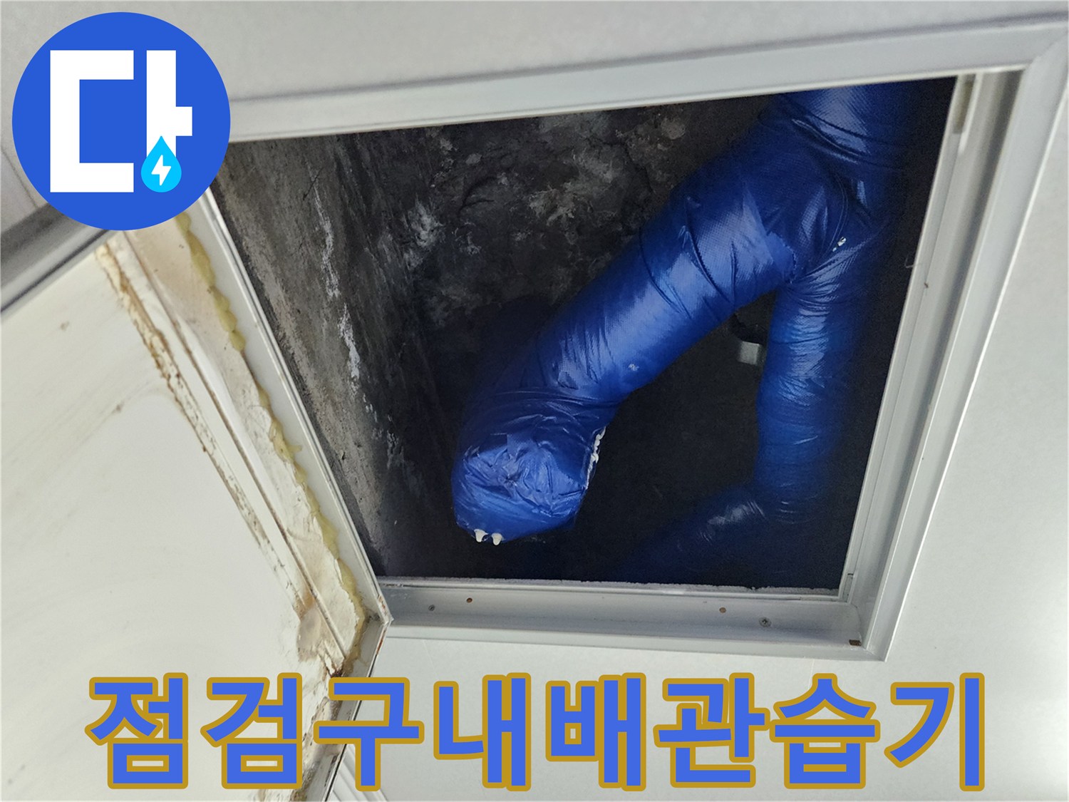 천장 점검구 내부의 젖어 있는 파란색 보온재 배관