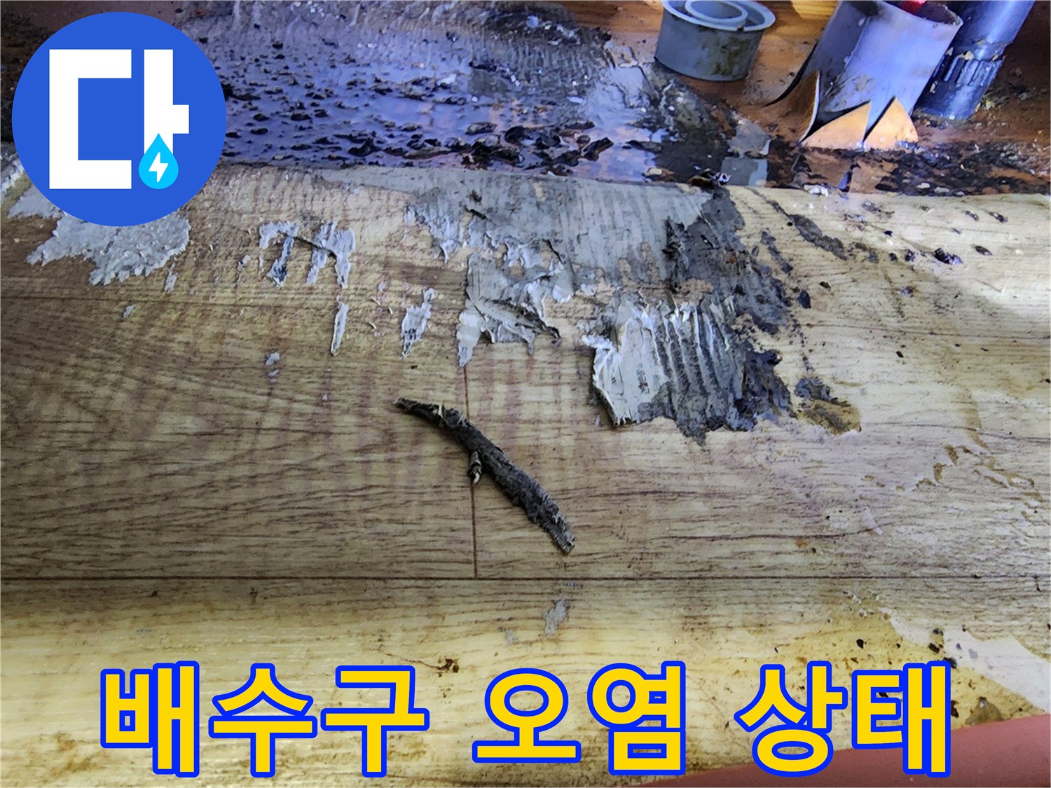 나무 판재 위에 흩뿌려진 검은색 이물질과 오염된 흔적들