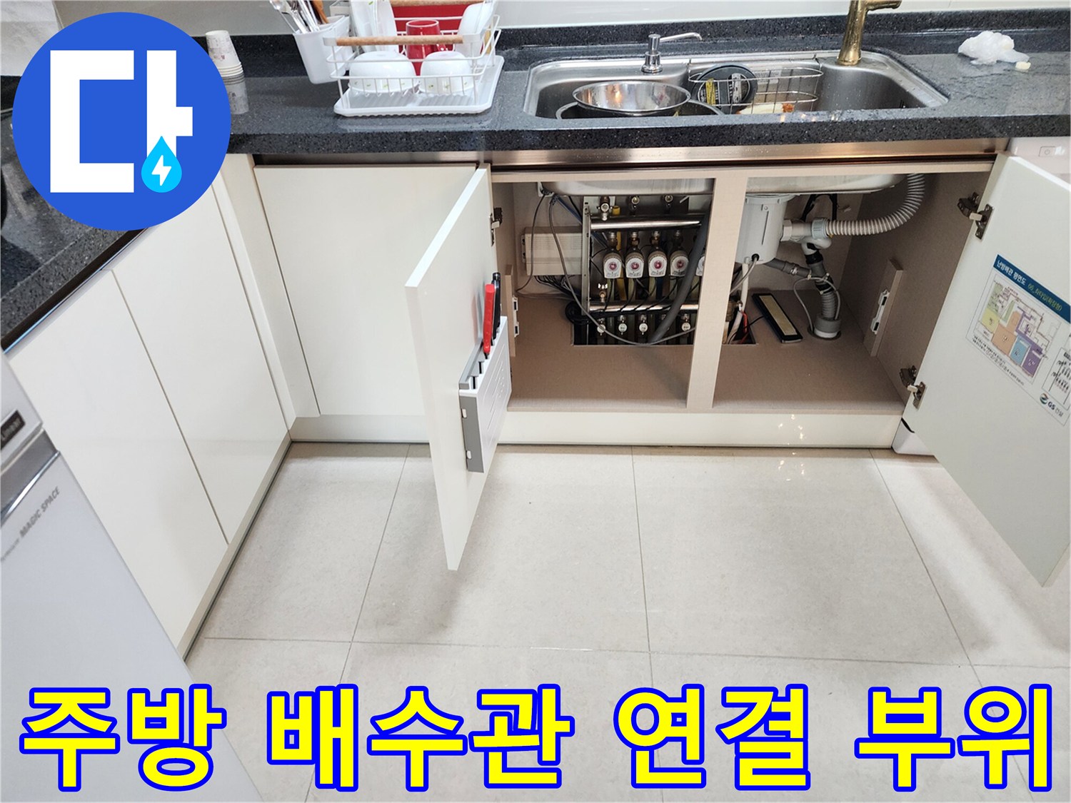 싱크대 아래쪽의 복잡한 배수 호스와 하수구 연결 상태