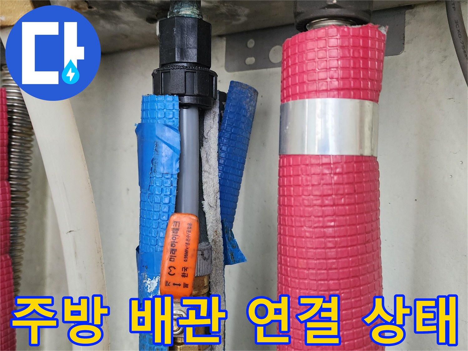 싱크대 하부의 분홍색 보온재 배관과 파란색 배관의 교차 지점