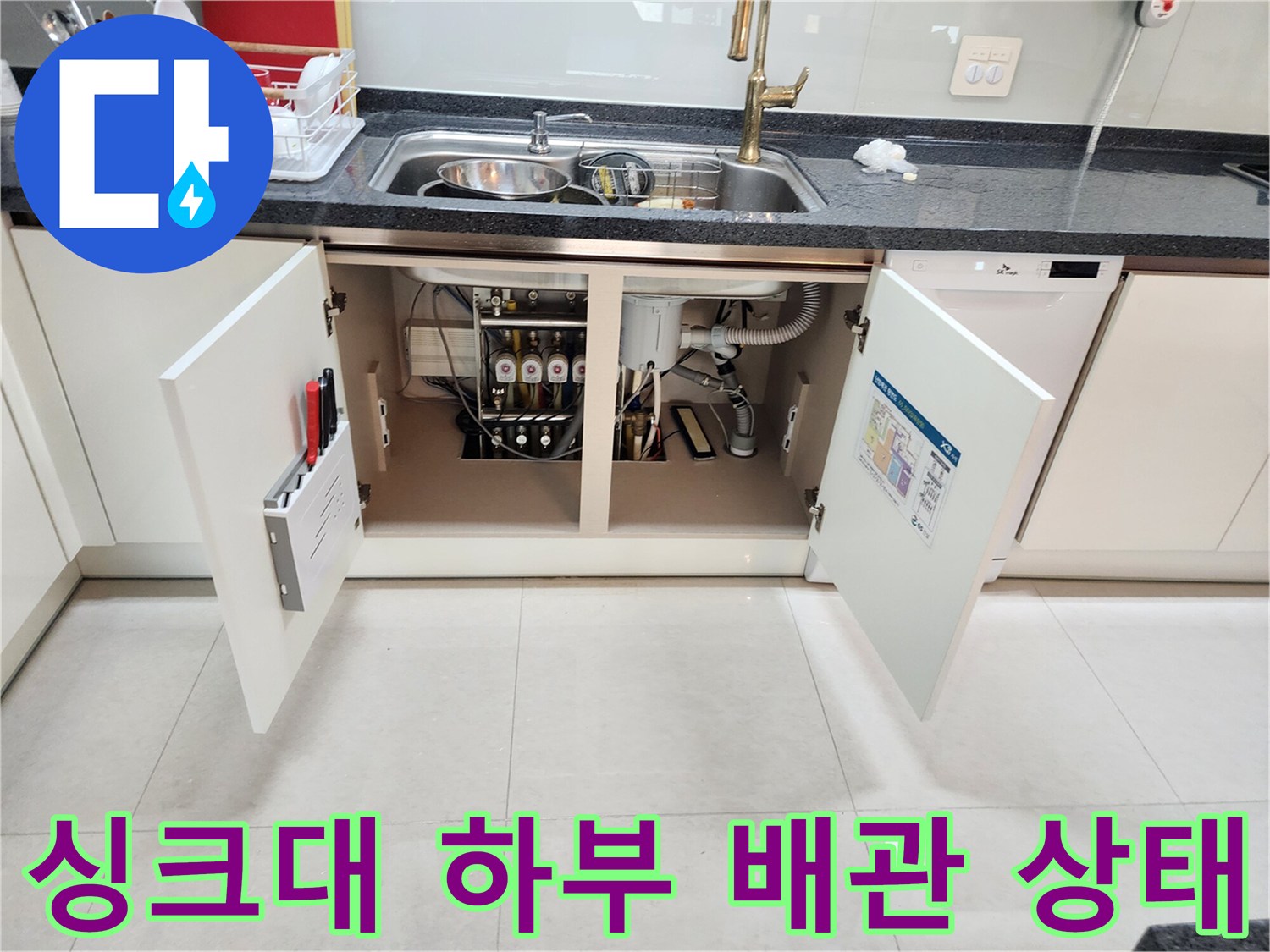 주방 싱크대 하부장 내부-복잡하게 연결된 배수 배관 점검 모습