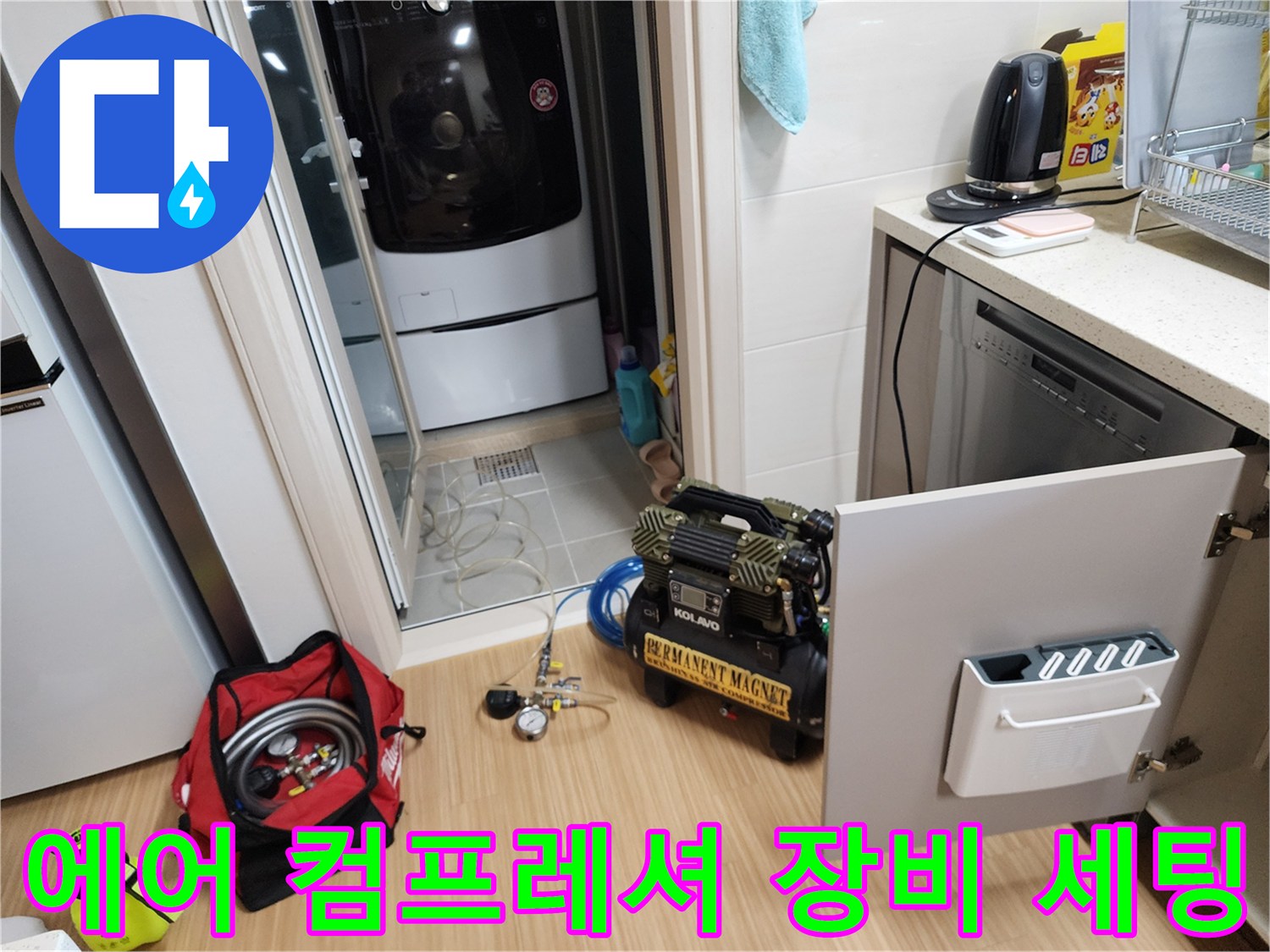 싱크대 하부 배관 작업을 위해 준비된 에어 압축기와 공구들