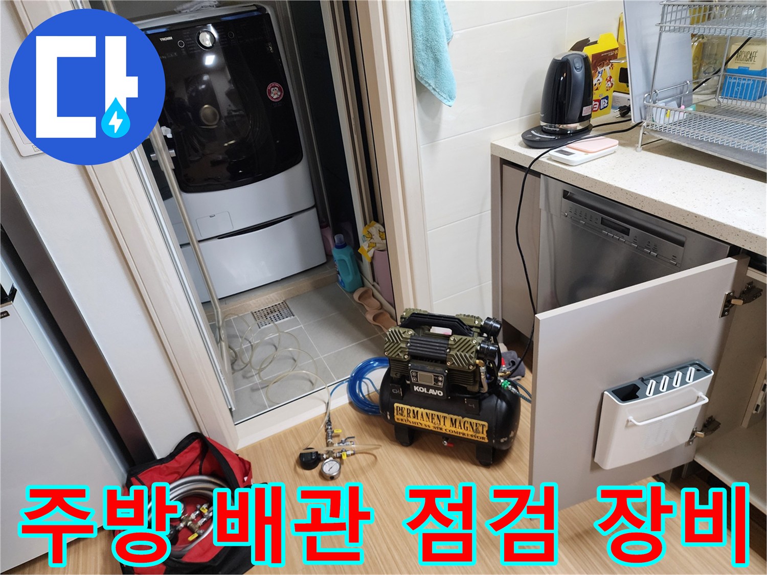 주방 싱크대 하부 공간에 배치된 전문 배관 진단용 컴프레셔 및 장비들
