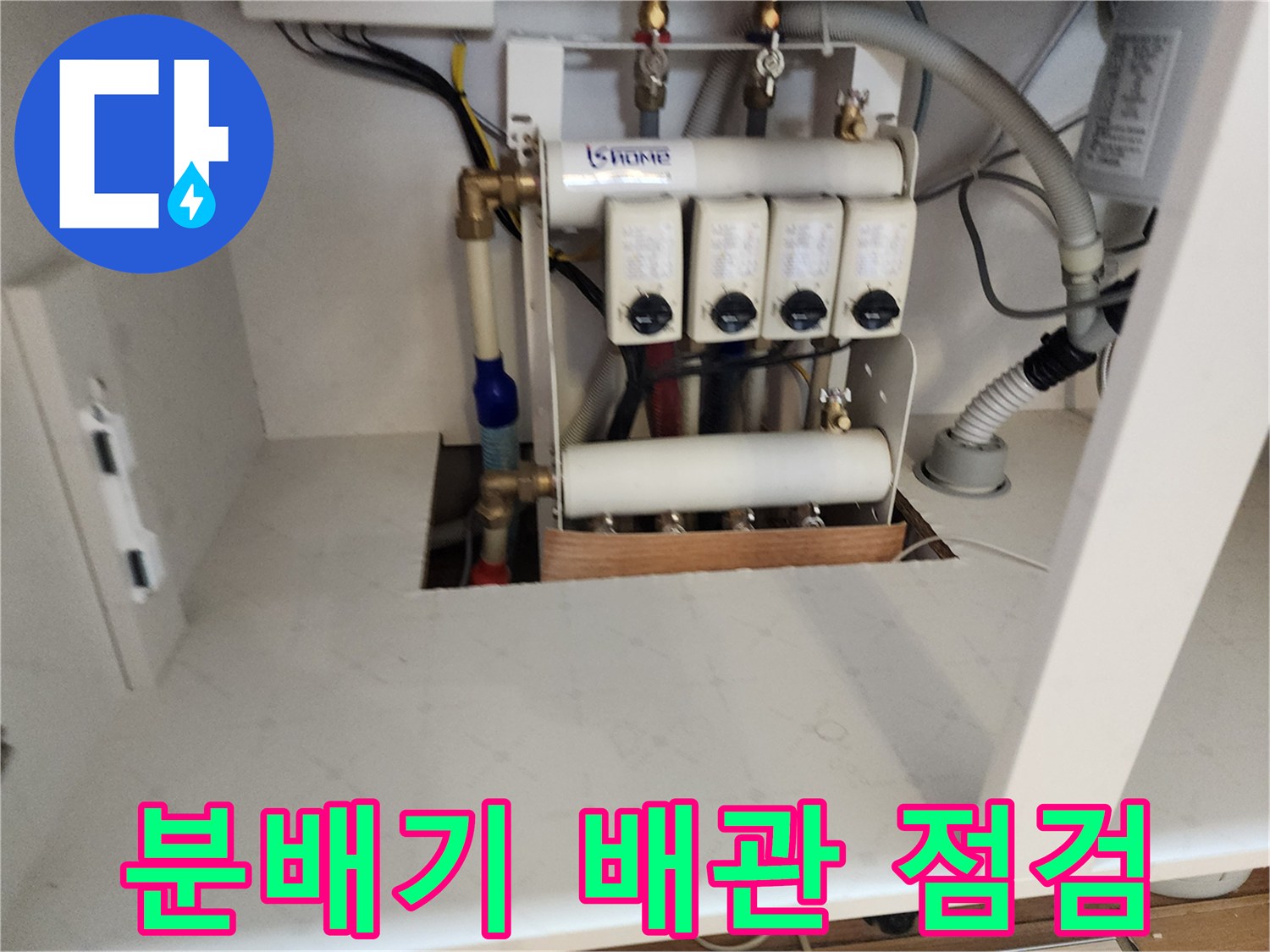 싱크대 아래 분배기와 연결된 각종 급수 및 난방 배관의 모습입니다.