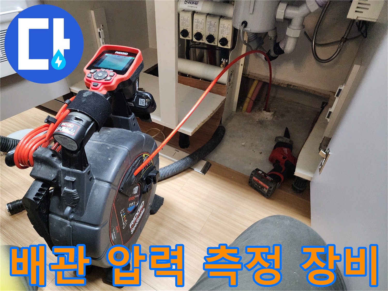싱크대 하부 배관의 공압 상태를 확인하기 위한 디지털 게이지와 호스 연결 모습입니다.