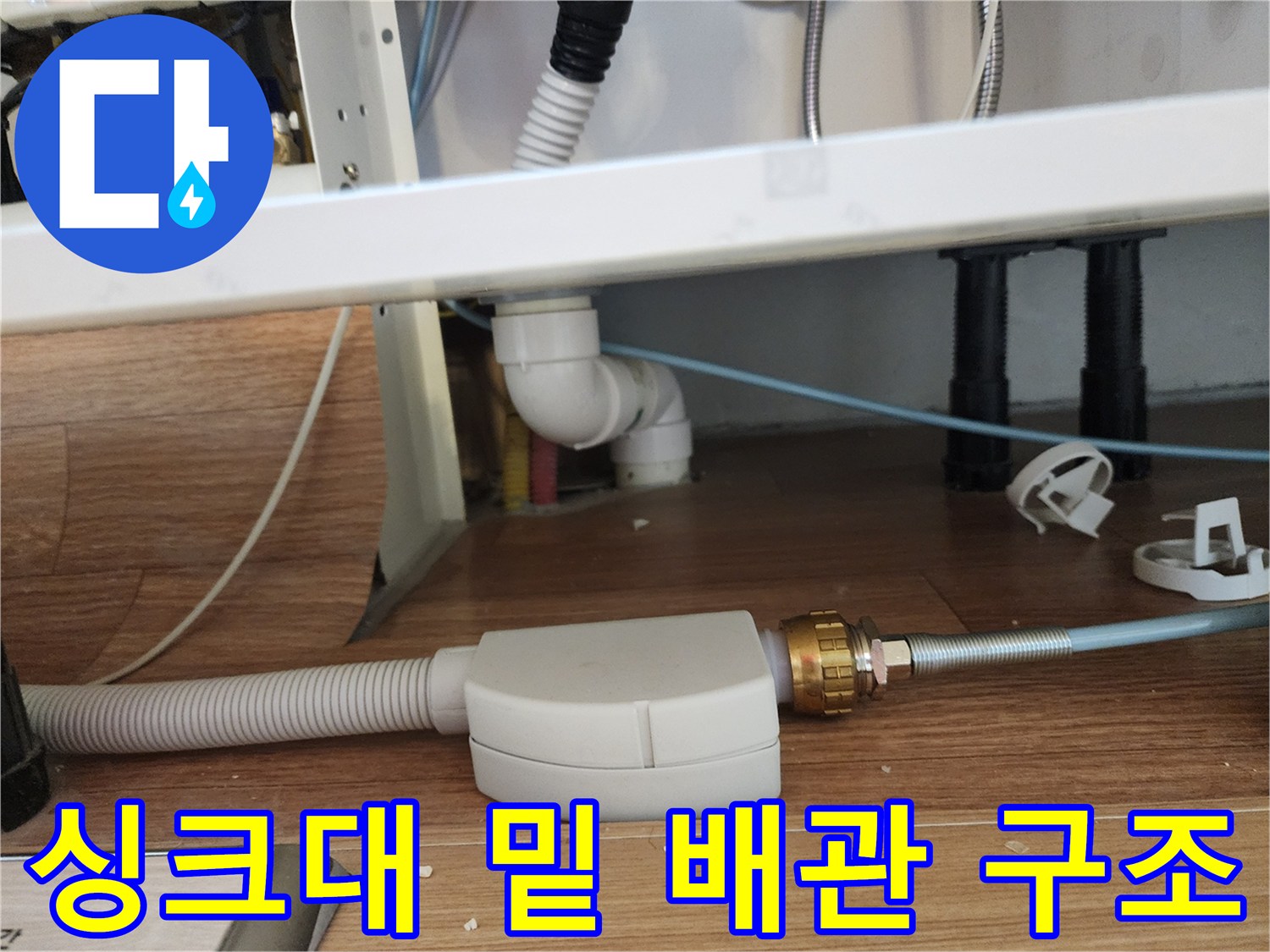 주름관 형태의 흰색 배관과 금속 연결 소켓 부위