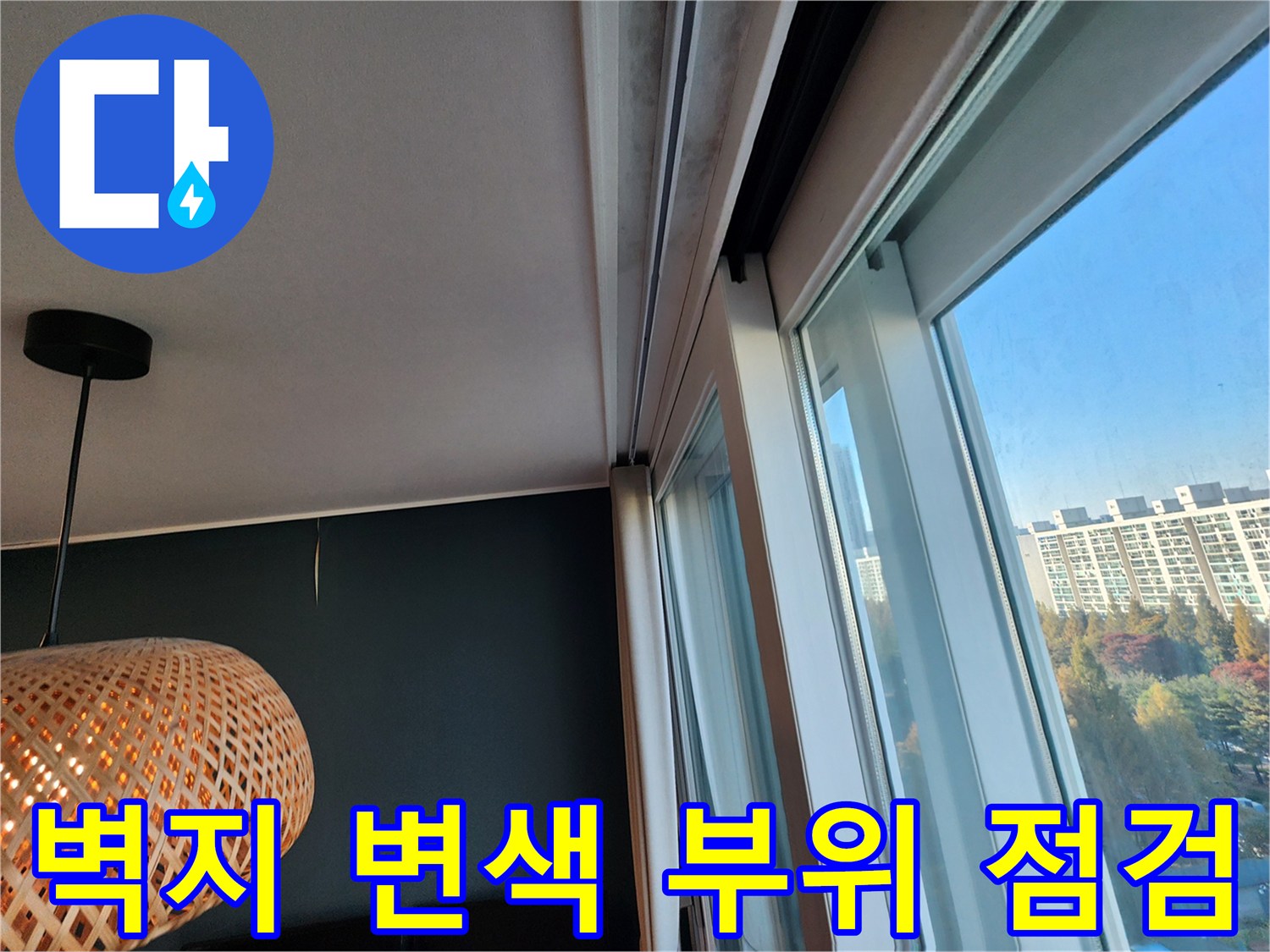 창문 옆 벽지 부분의 습기 흔적을 촬영한 사진입니다.