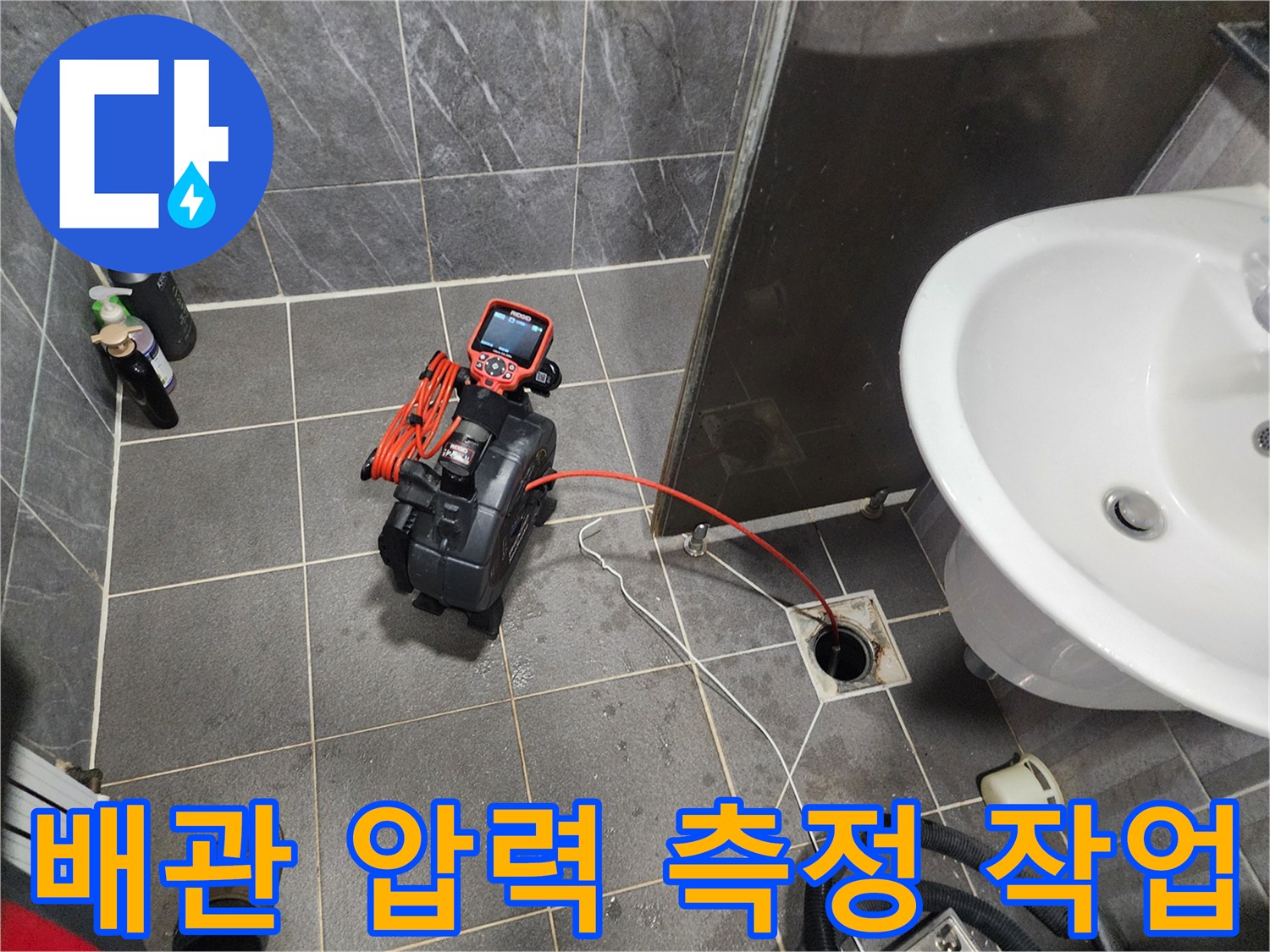 배수구 입구 주변에서 진행 중인 배관 압력 진단 과정