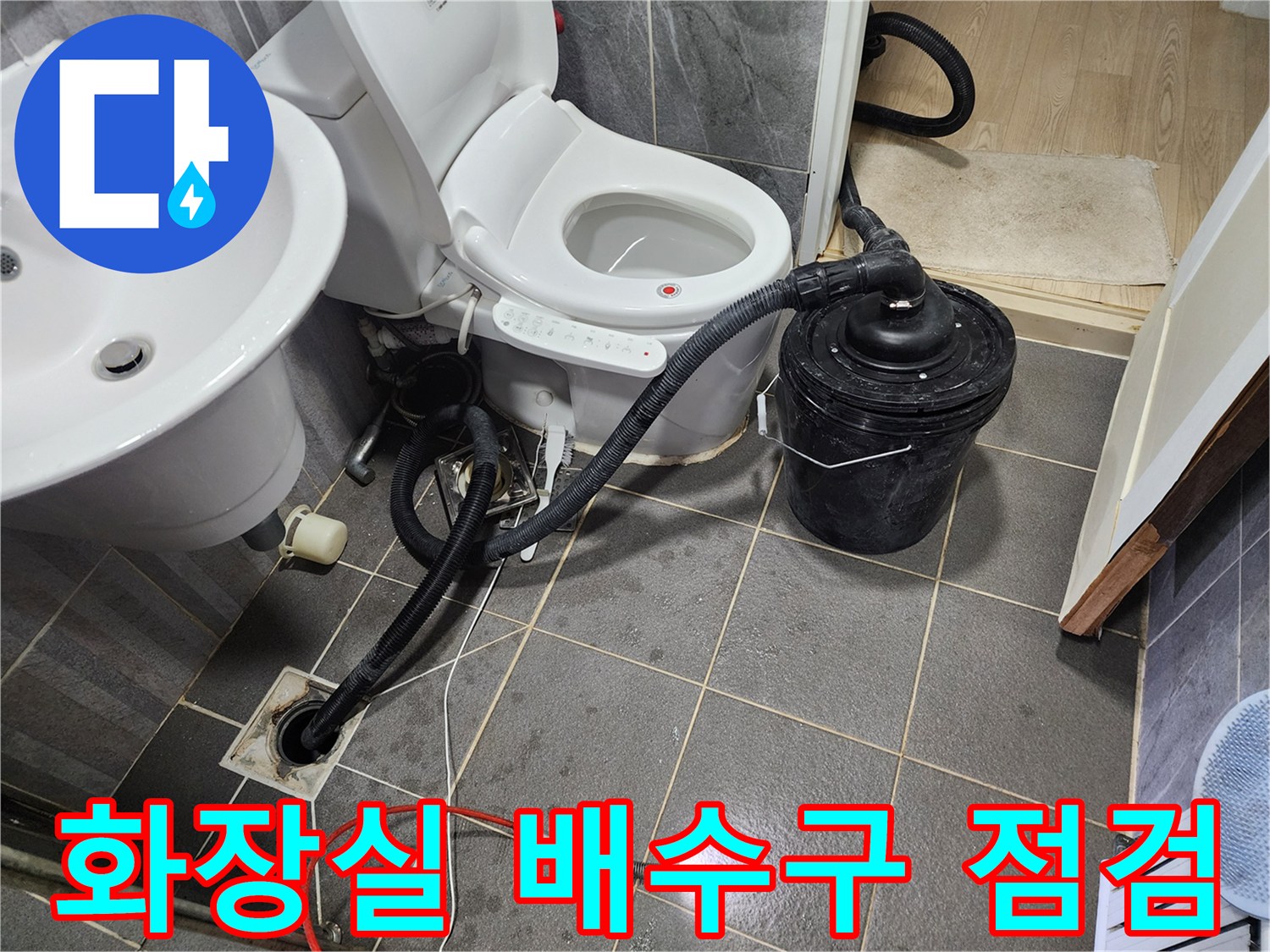 화장실 바닥 배수구에 연결된 전문 장비와 흡입기 모습