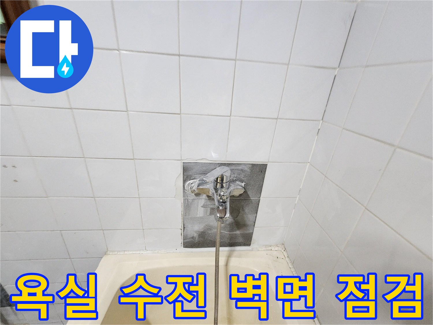 욕실 타일 벽면에 설치된 수전과 샤워기 호스 모습