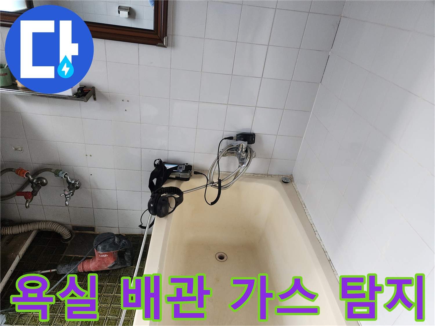 욕실 타일 벽면에 연결된 배관의 누출 부위를 찾기 위해 가스 탐지기를 설치한 모습입니다.