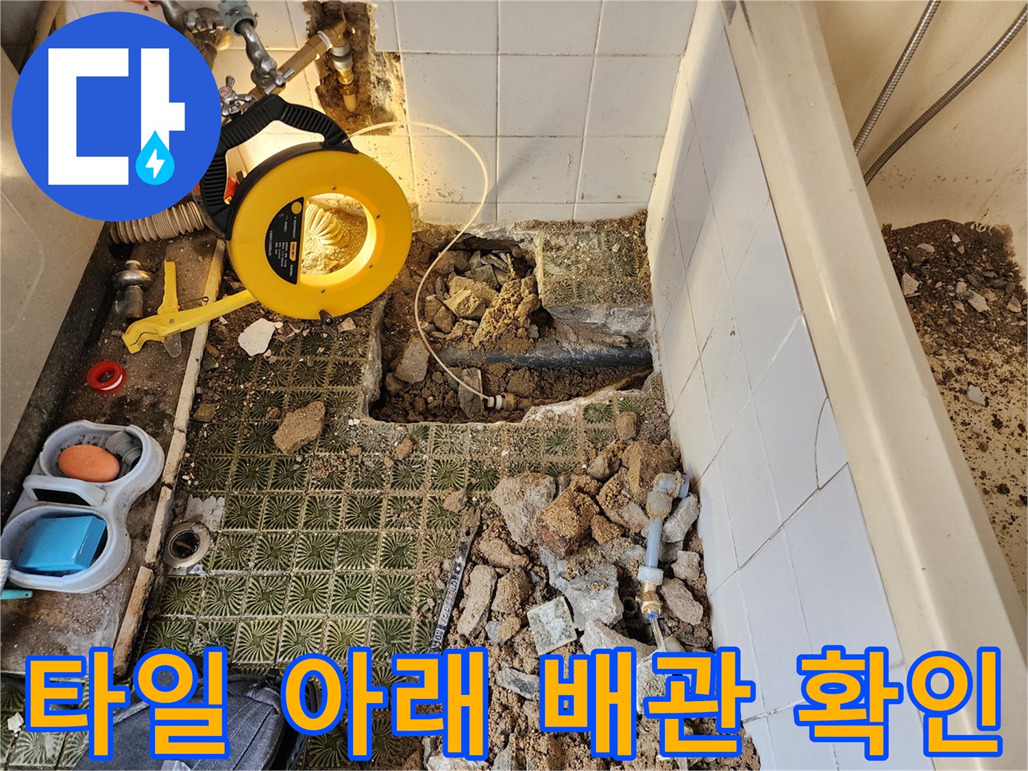 욕실 타일을 걷어내고 드러난 젖은 토사와 배관 부위