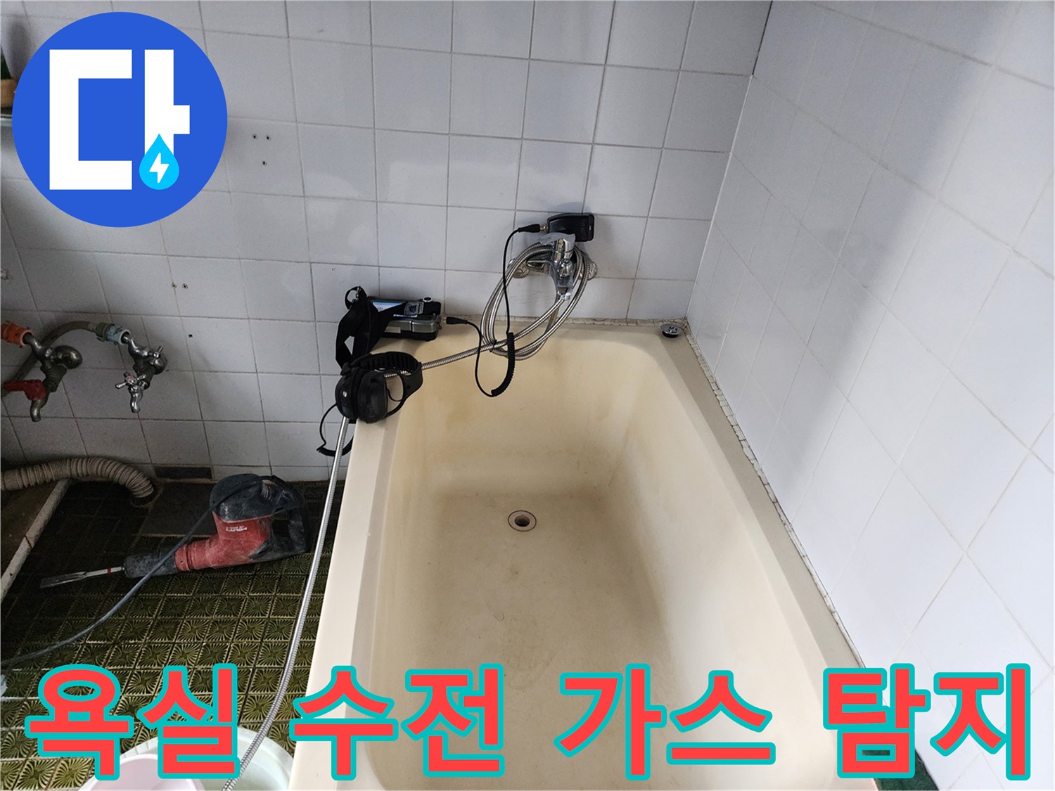 타일 벽면에 설치된 수도 부속과 연결된 탐지용 호스의 모습입니다.