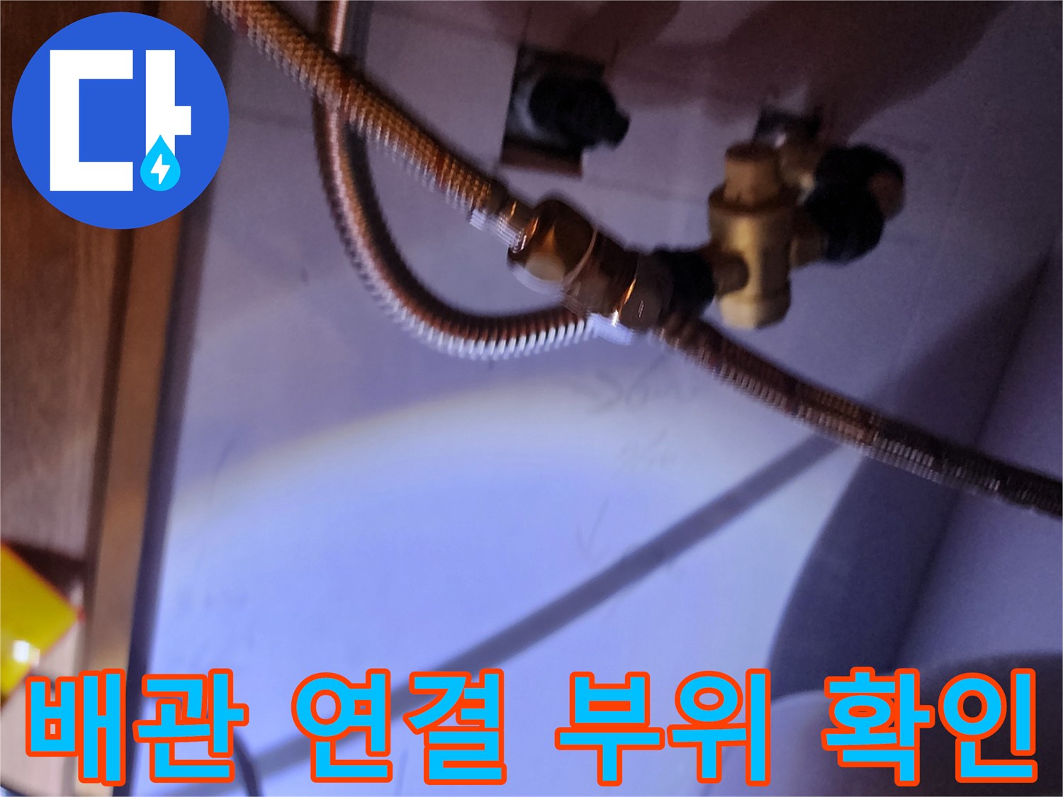 전기 온수기와 연결된 황동색 밸브 및 금속 호스 근접 촬영