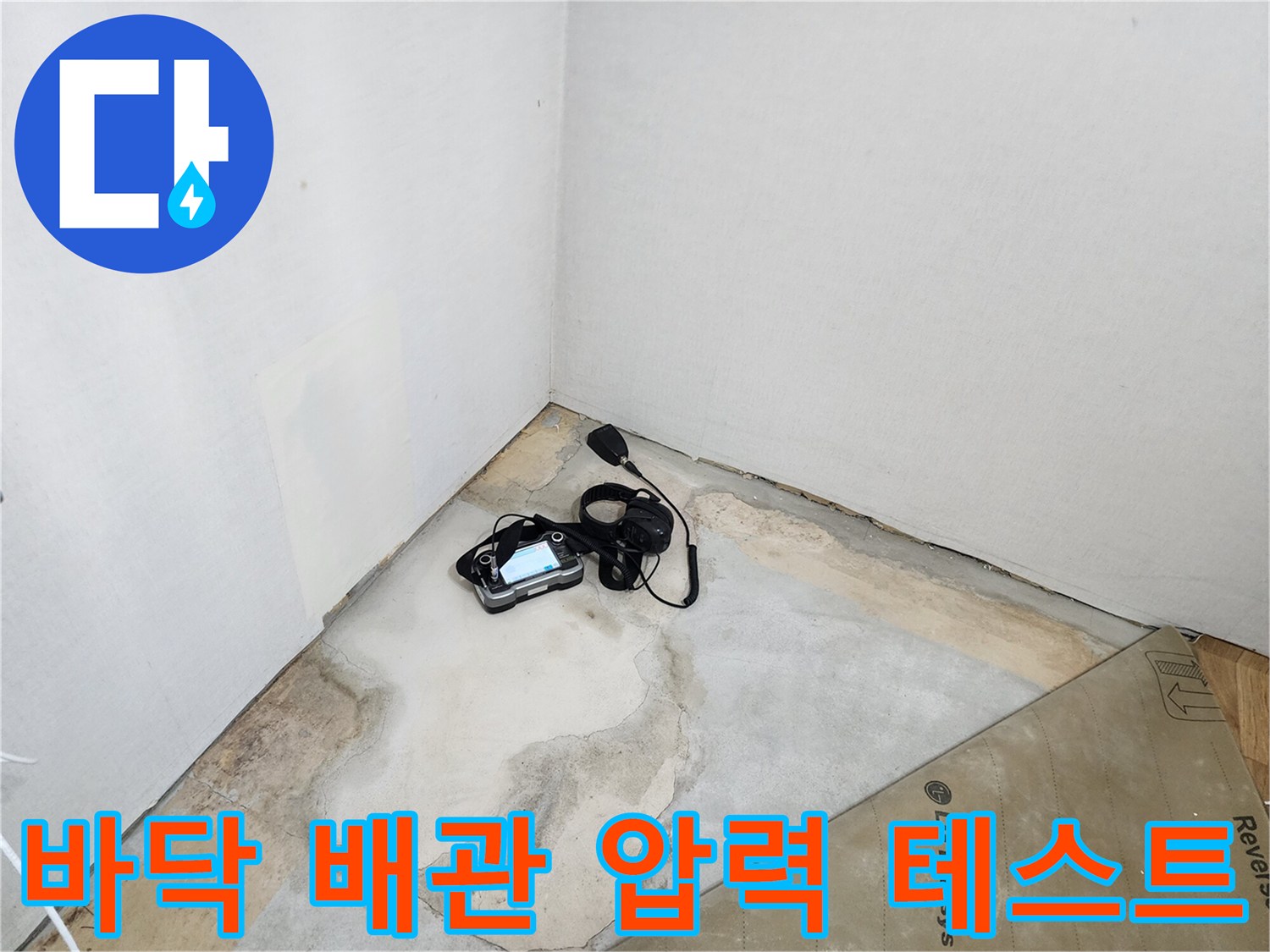 콘크리트 바닥 위로 드러난 습한 지면과 배관 누수 확인을 위한 압력계 설치 모습