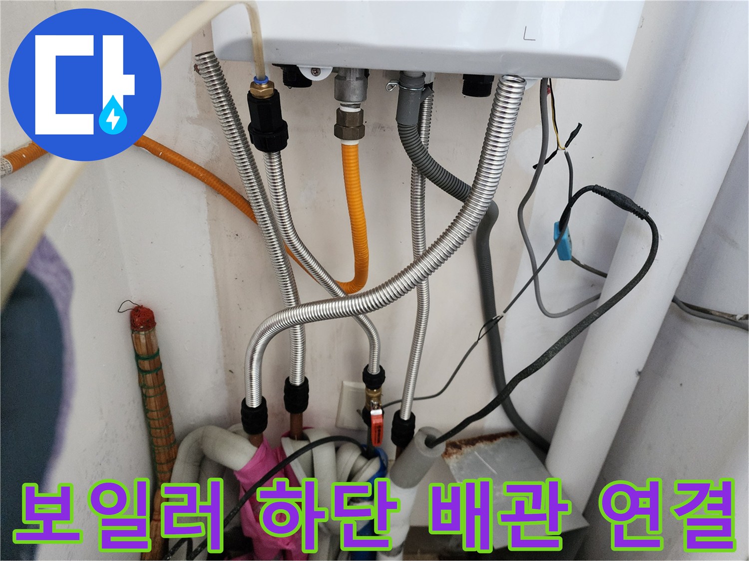 금속 자바라와 노란색 호스가 결합된-보일러 하부 배관 상세 사진