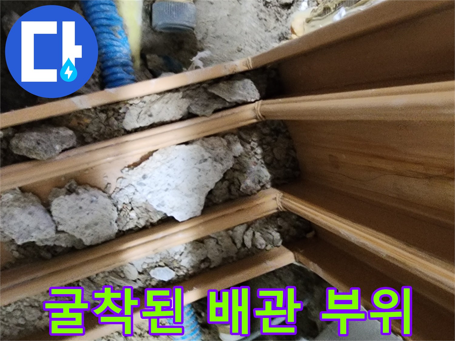 나무 마감재 아래로 드러난 노란색과 파호색 배관의 누수 의심 구간