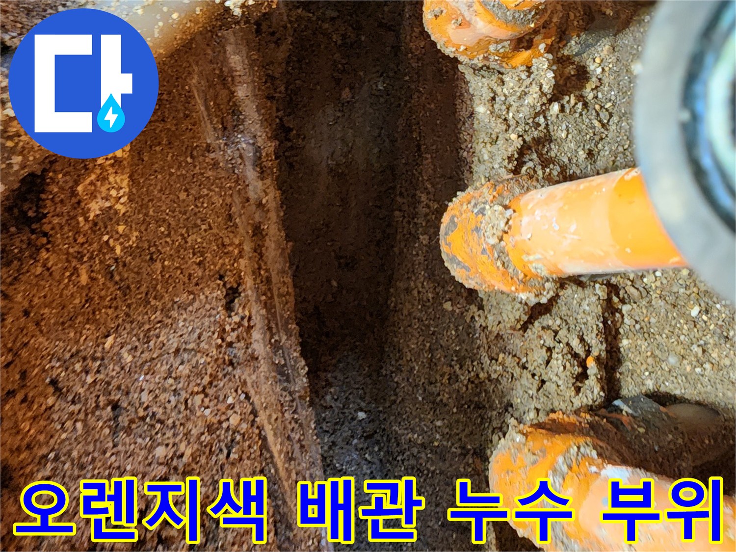 오렌지색 보온재로 감싸진-매립 배관의 연결부 틈새로 물이 새어 나오는 모습