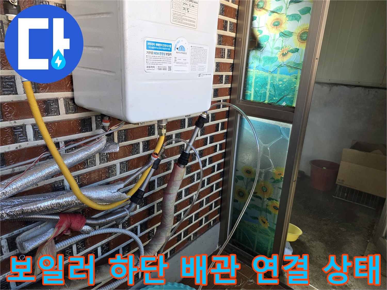 벽돌 벽면에 설치된 보일러와 하단 배관들의 상세 모습