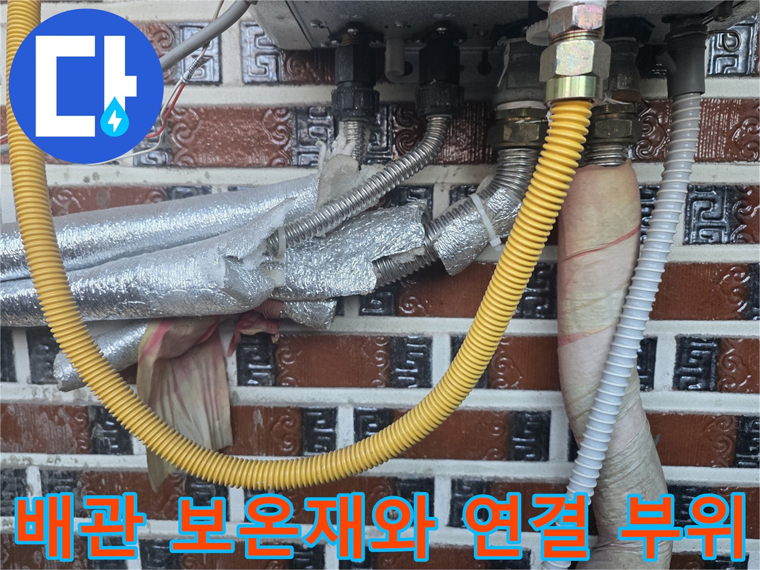 은박 보온재로 감싸진 난방 배관과 노란색 호스 연결 상태