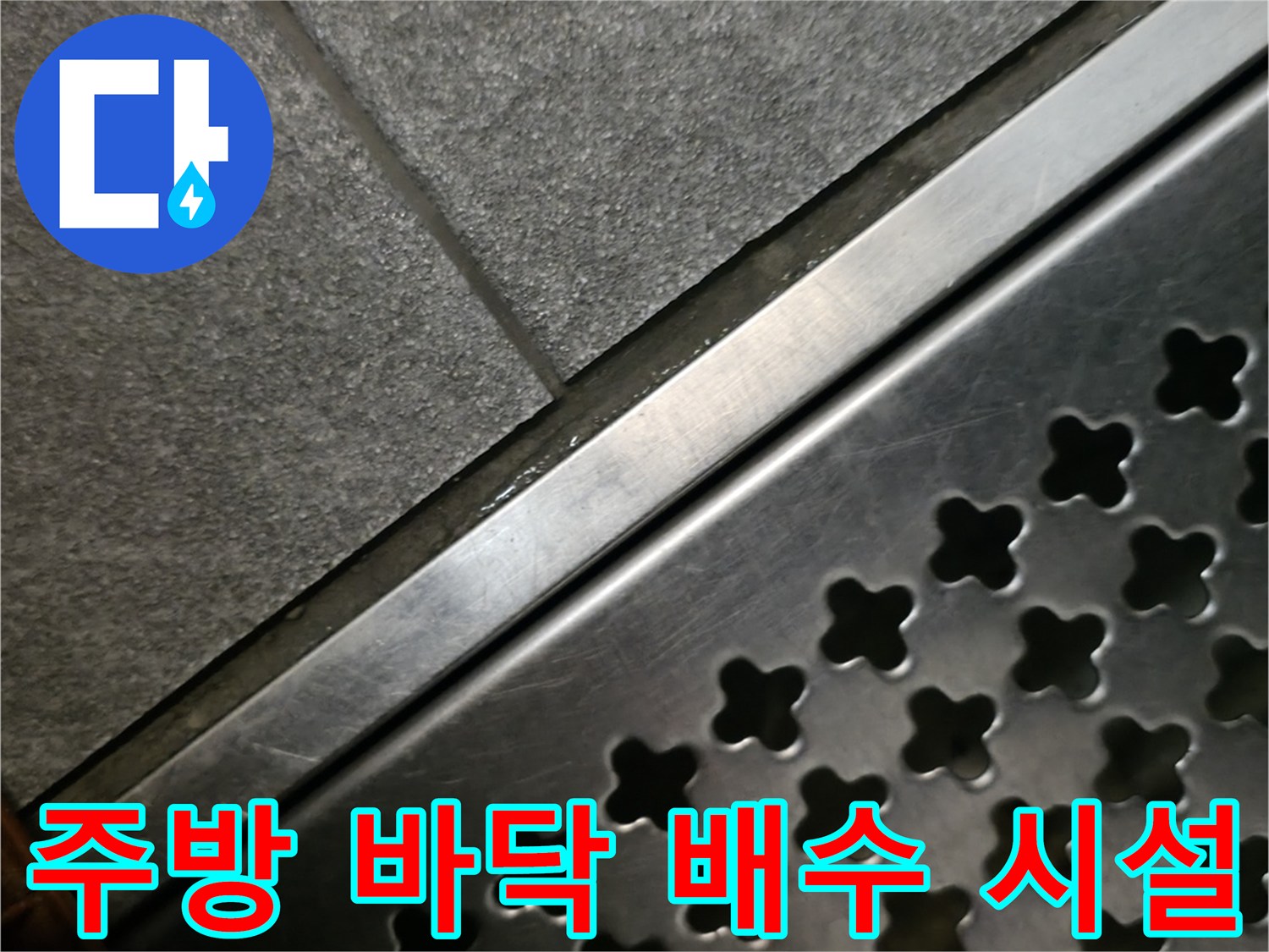 스테인리스 소재의 배수 트렌치와 인접한 타일 바닥 사진입니다.