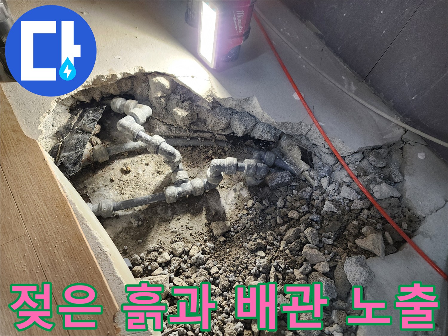 콘크리트 아래 드러난 누수 지점의 회색 배위 부속들