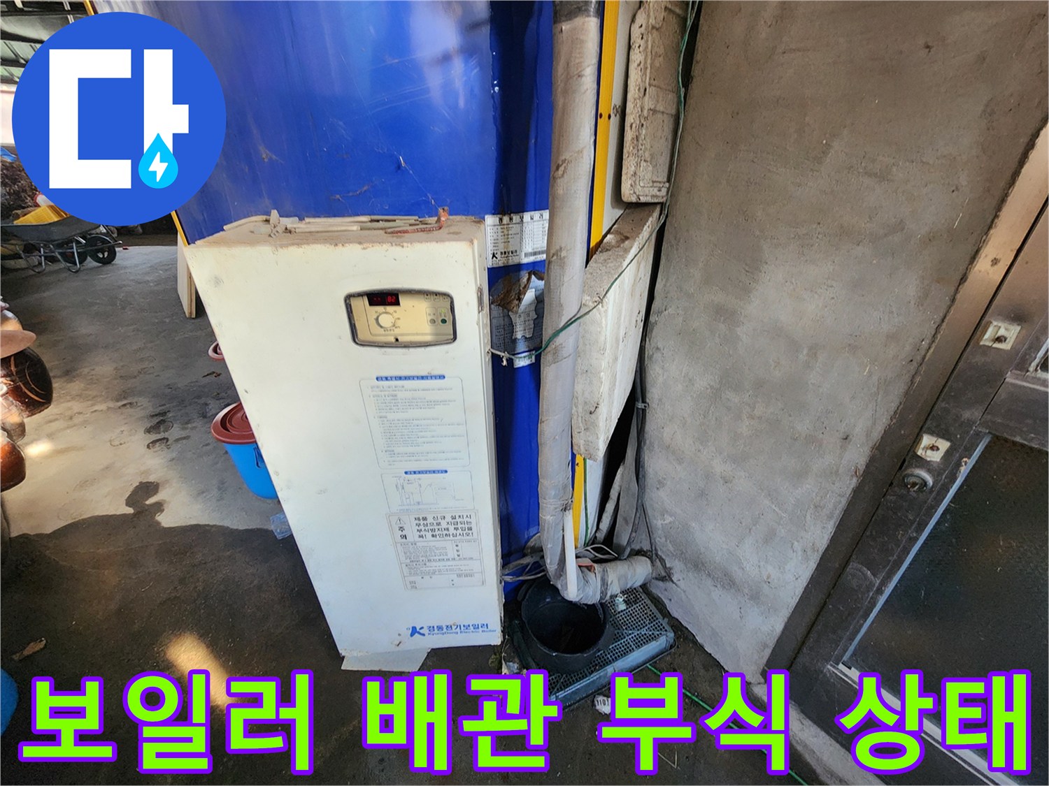 파란색 전기 보일러와 부식된 연결 배관 모습