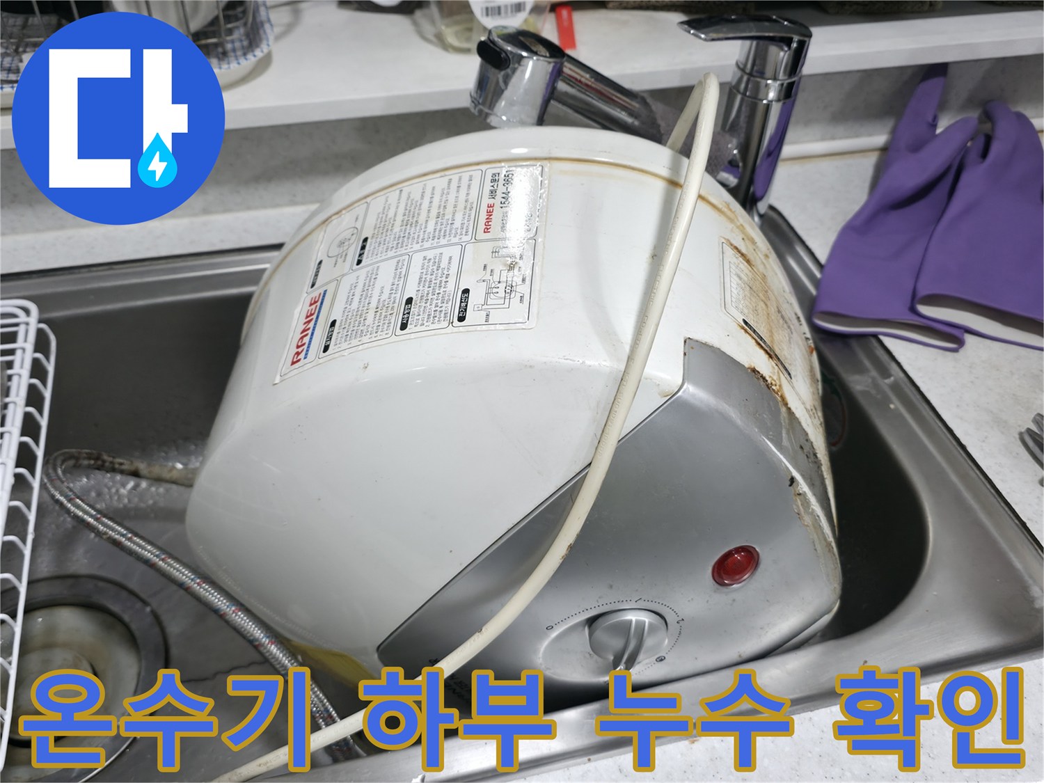 사무실 싱크대 아래 설치된 소형 전기 온수기의 배관 부식 상태를 점검하는 모습입니다.