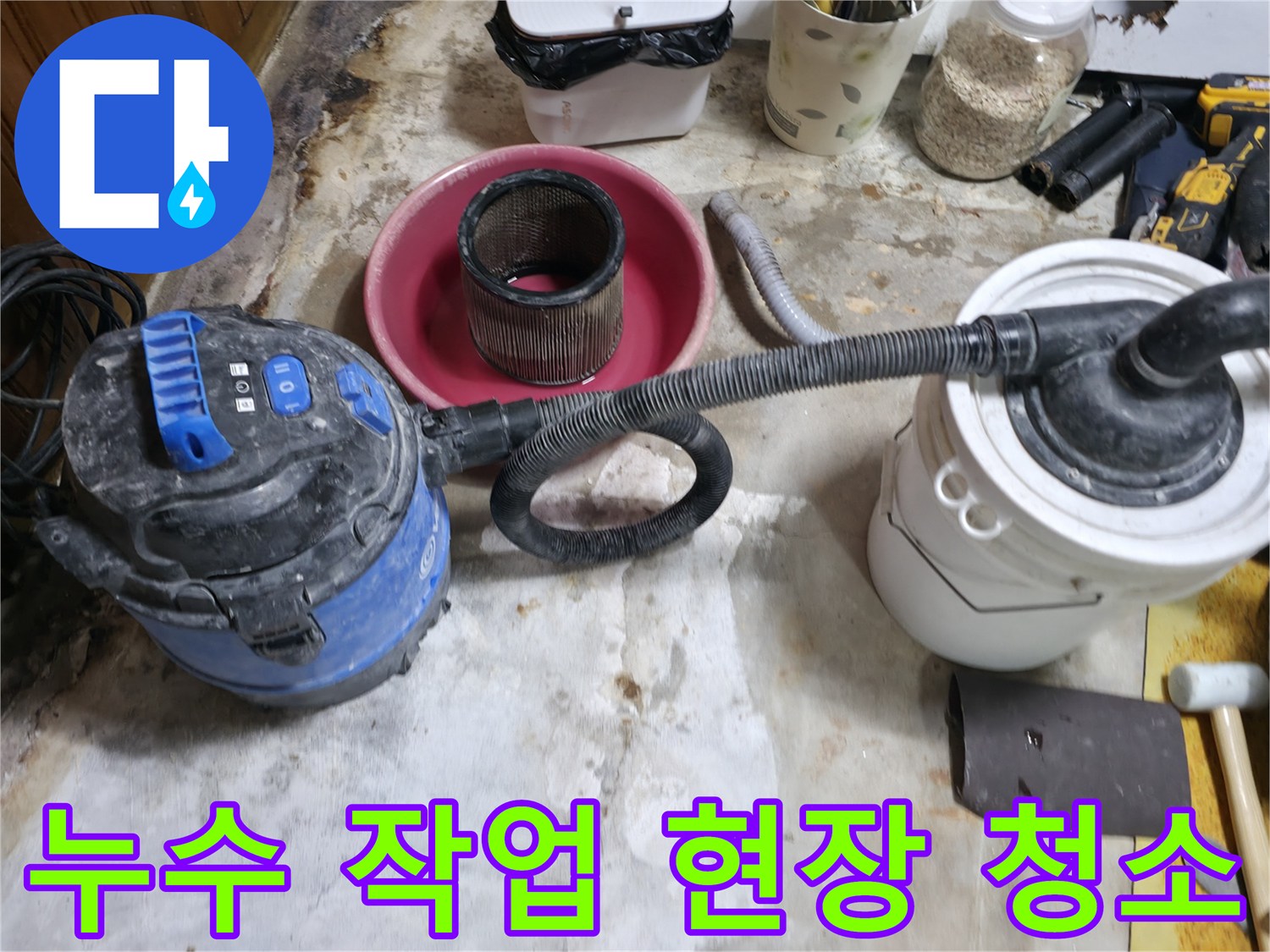 누수 보수 공사 후 발생한 잔해물을 진공청소기로 정리하는 모습입니다.