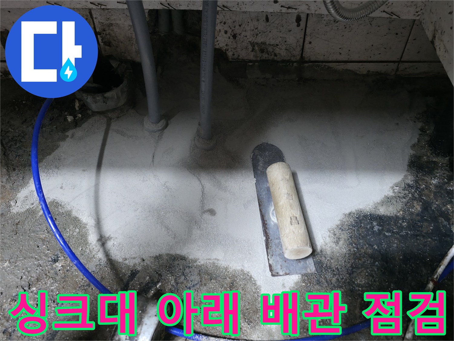 싱크대 하단 배관 주변의 젖은 바닥과 배관 연결 부위