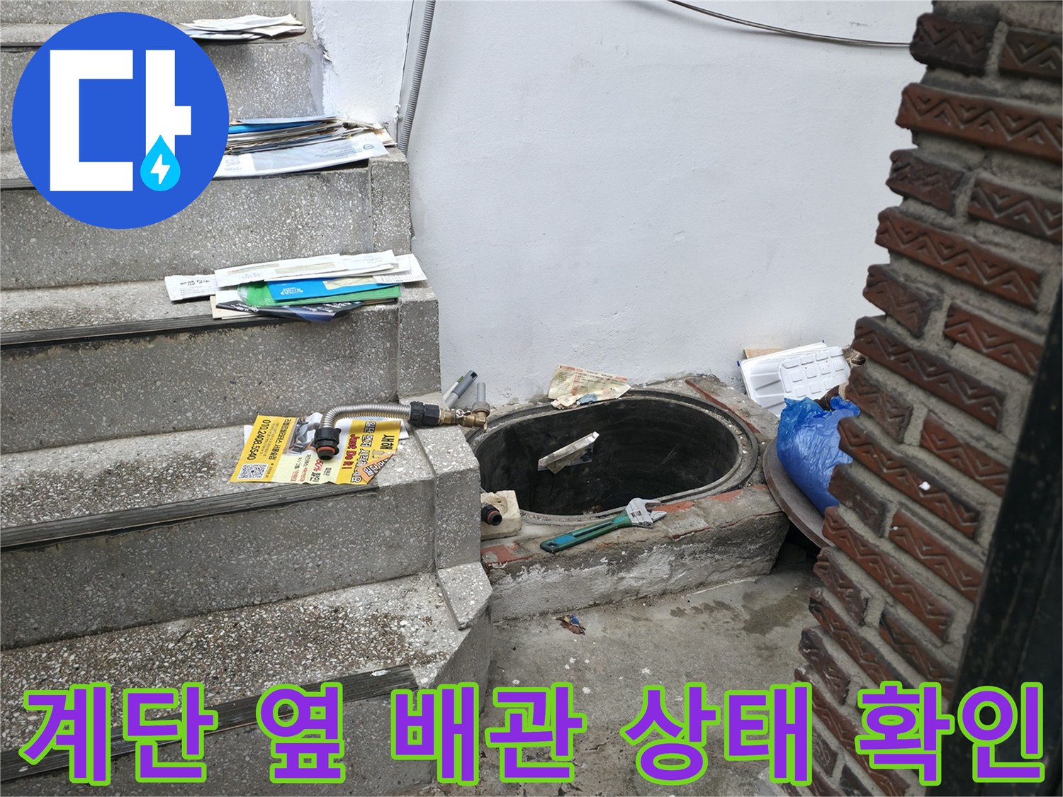 외부 계단 인근 배관 주변의 물샘 흔적을 점검하는 장면입니다.