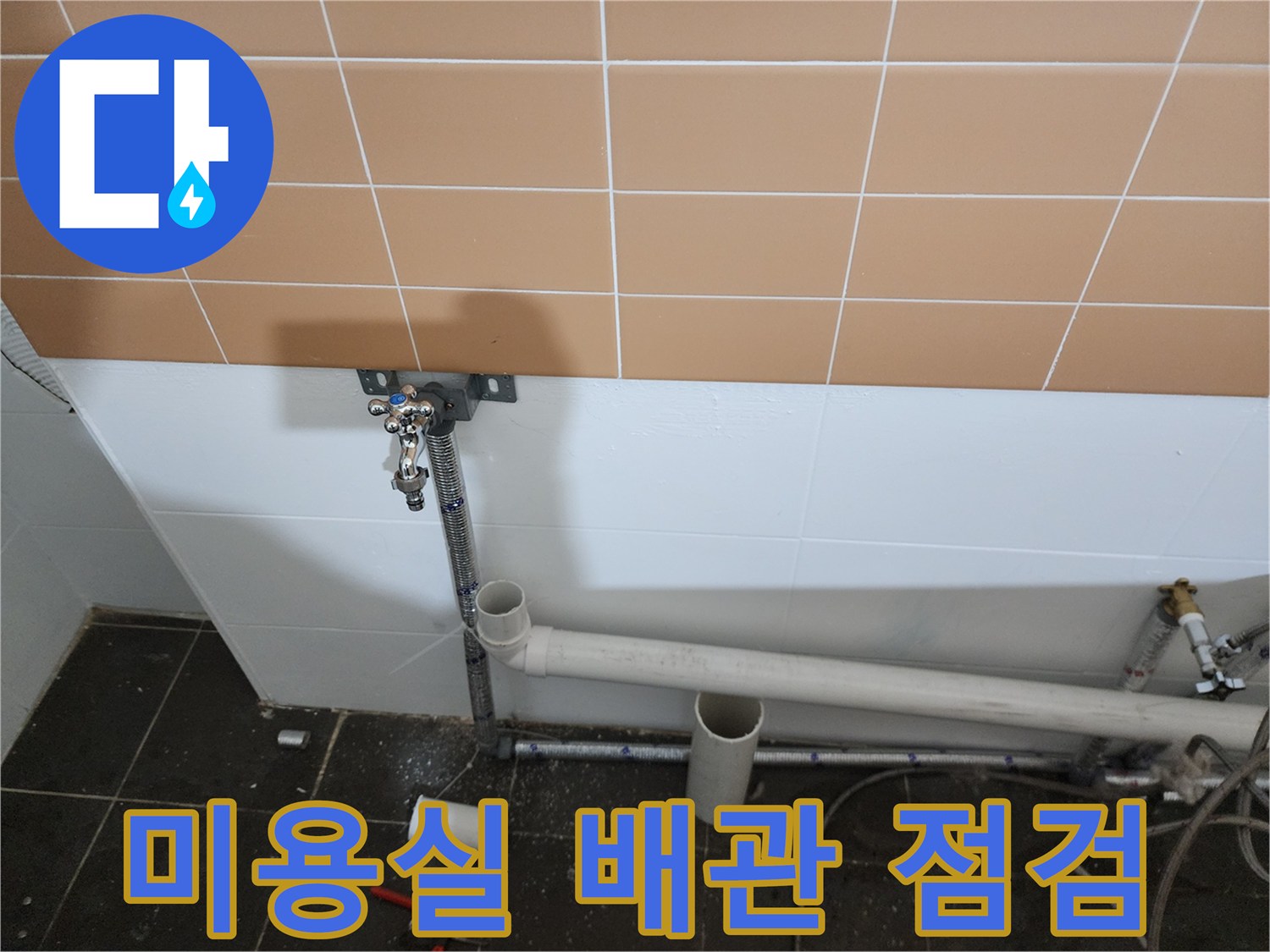 미용실 벽면 하단에 설치된 PVC 배관과 수도 연결 부위 사진입니다.