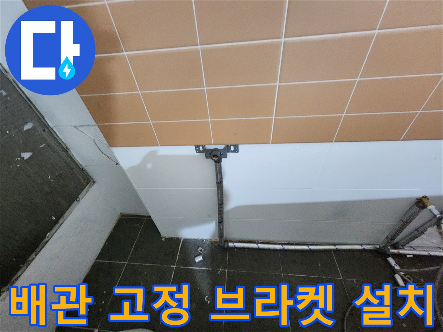 벽면 타일 부근에 고정된 배관 지지대와 수평 배관