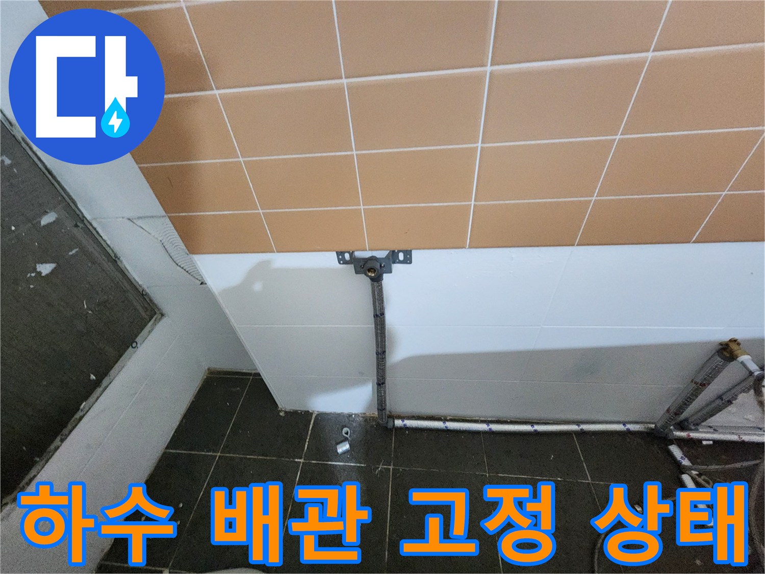 벽면 타일과 연결된 배관 지지대 및 하수관 부위