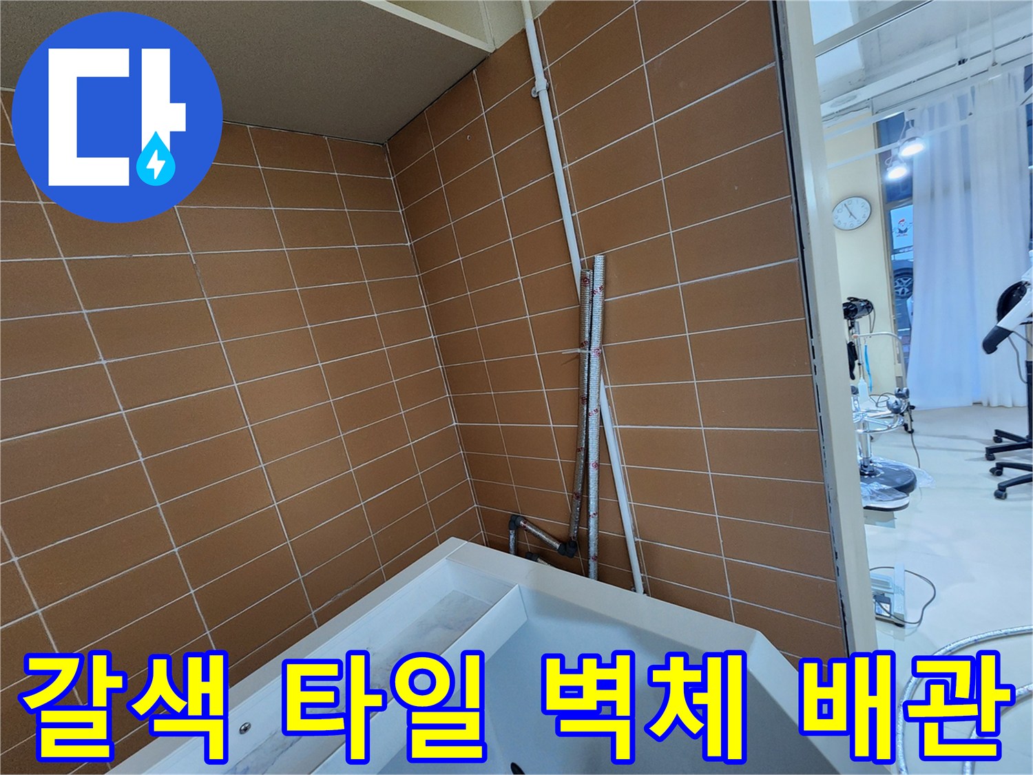브라운 톤 타일 벽면에 수직으로 배치된 배관 구조