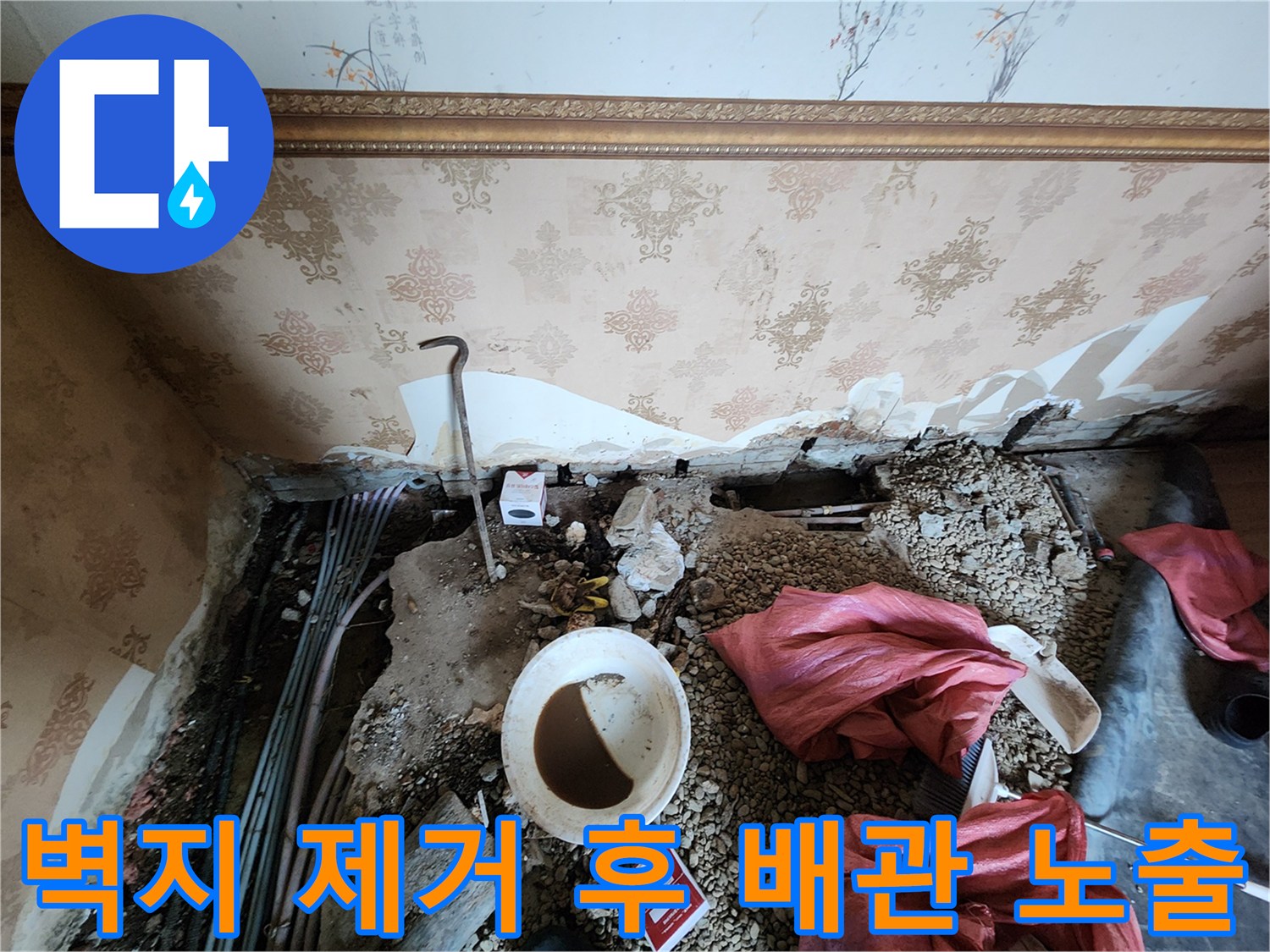 누수 지점 확인을 위해 벽면 마감재를 철거하고 배관을 드러낸 모습