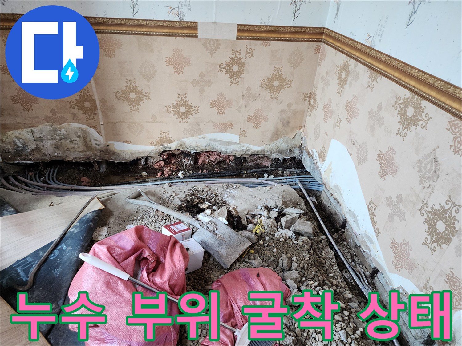 벽면 하단 마감재 제거 후 드러난 배관과 파헤쳐진 바닥 내부 모습