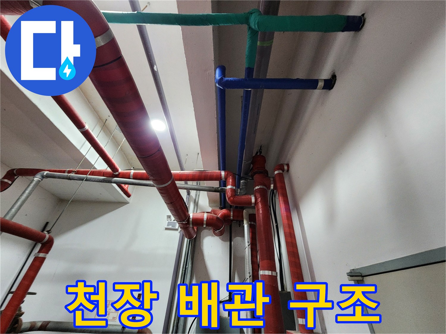 보온재로 감싸진 천장 내부의 붉은색 및 파란색 배관들