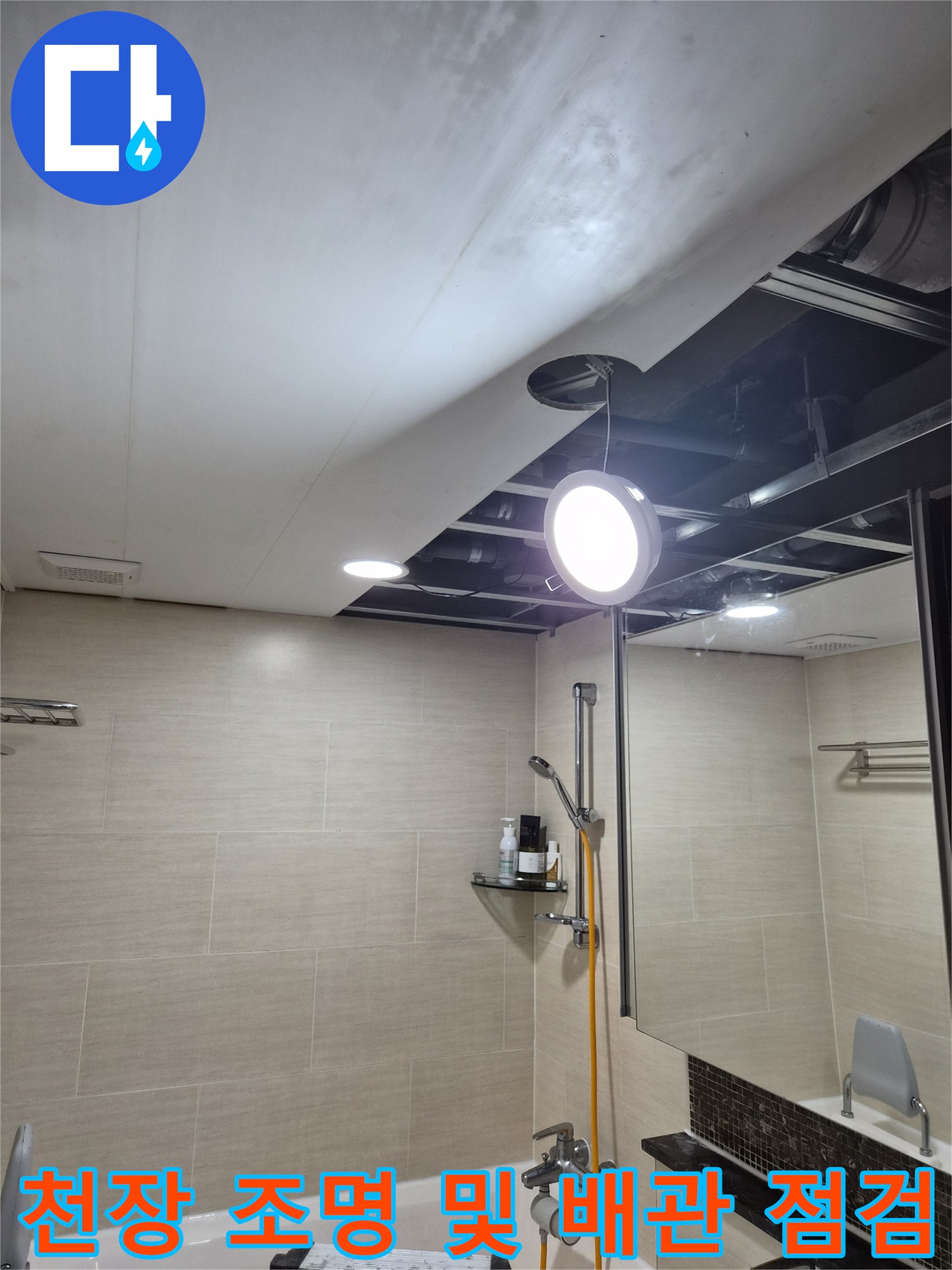 화장실 천장 조명과 노출된 배관 부위의 근접 촬영