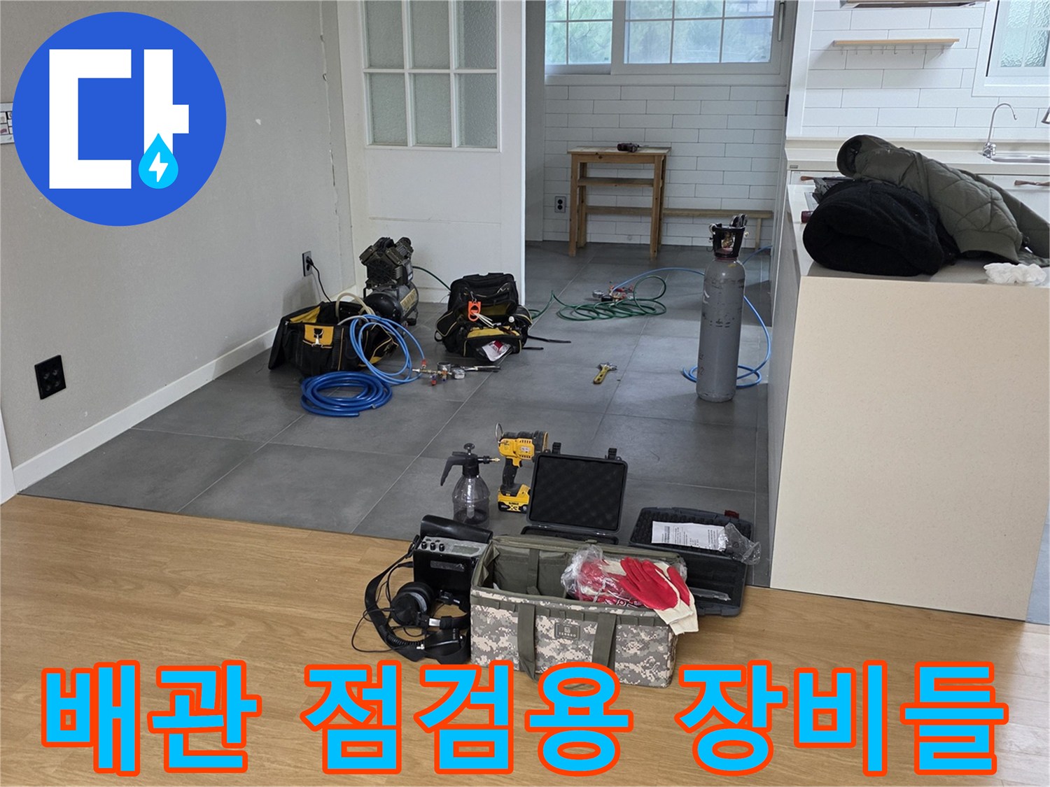 거실 바닥에 세팅된 누수 탐지 장비-가스 탐지기와 공구함 및 압력계 구성