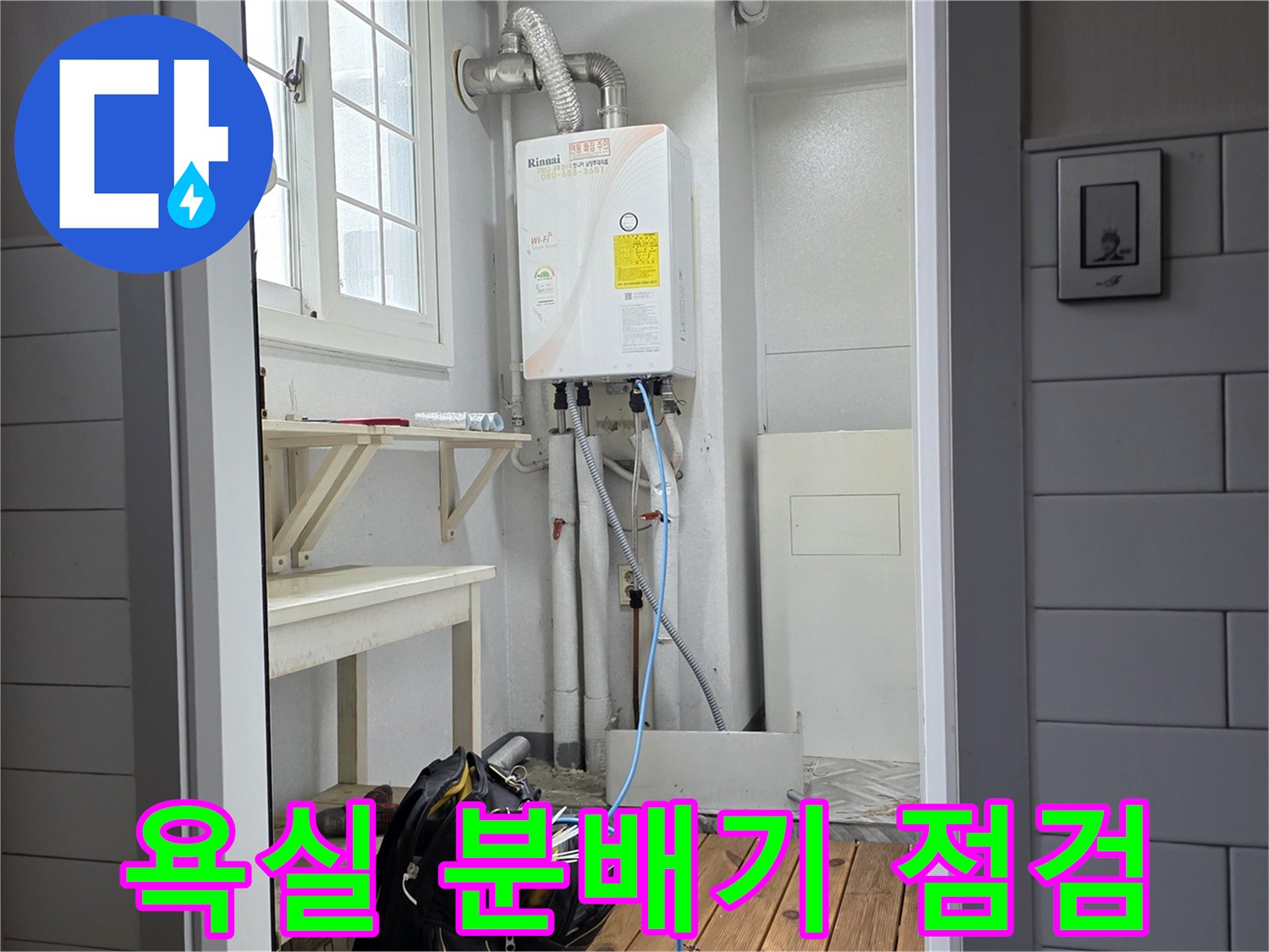 벽면 하단에 위치한-온수 분배기와 연결된 배관의 정밀 점검 모습입니다.