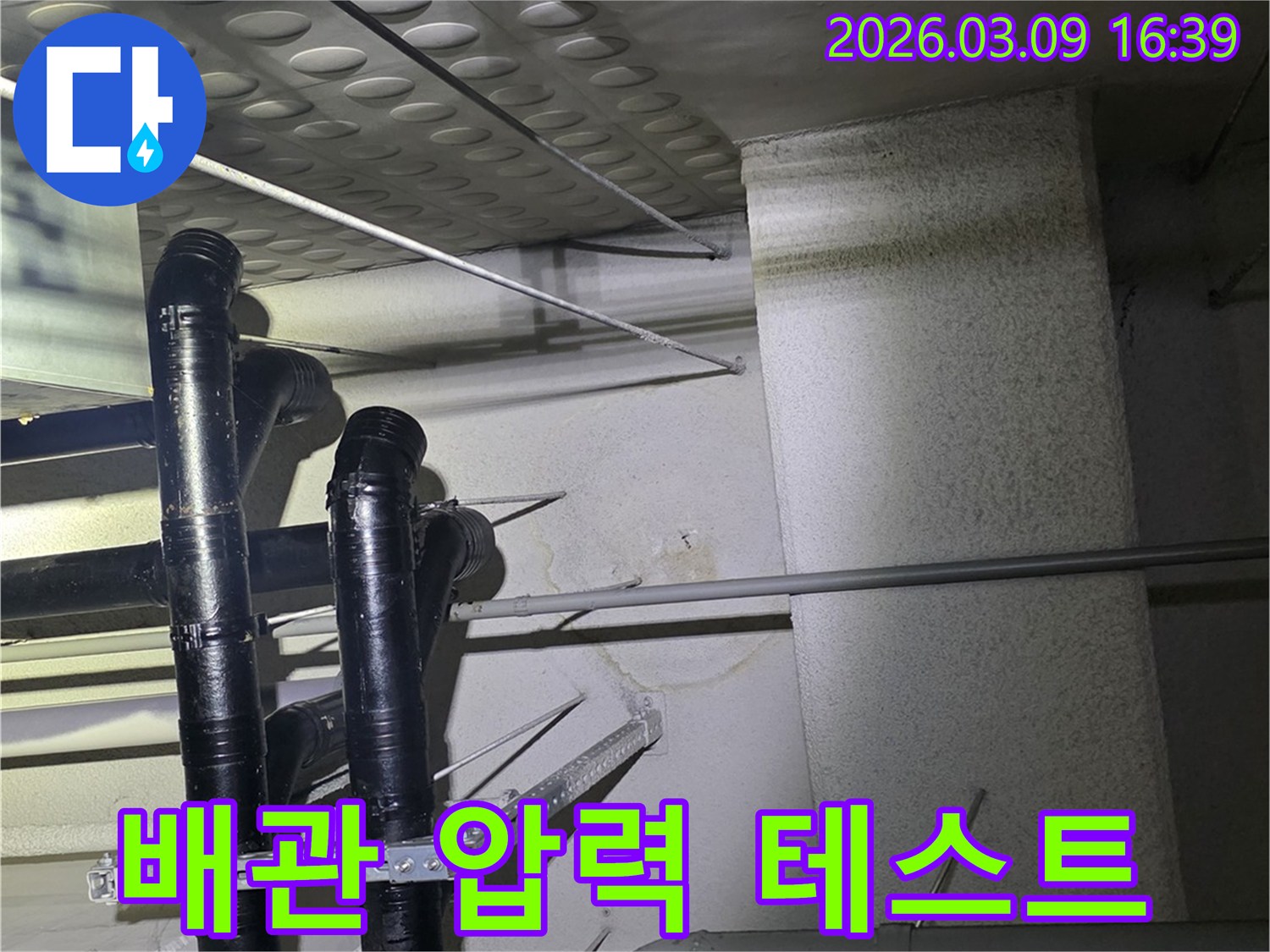 천장 배관에서-물이 새어-벽면에-얼룩이-생긴-모습을-확인하고-배관 압력-테스트를-통해-누수 원인을-찾는-현장 사진