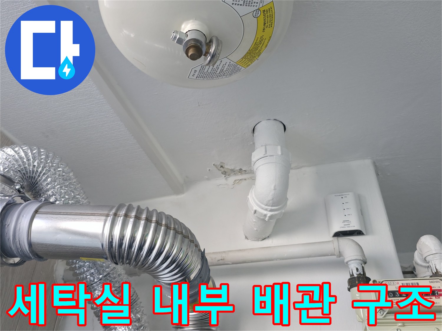 가스계량기와 흰색 하수 배관이 설치된 세탁실 벽면