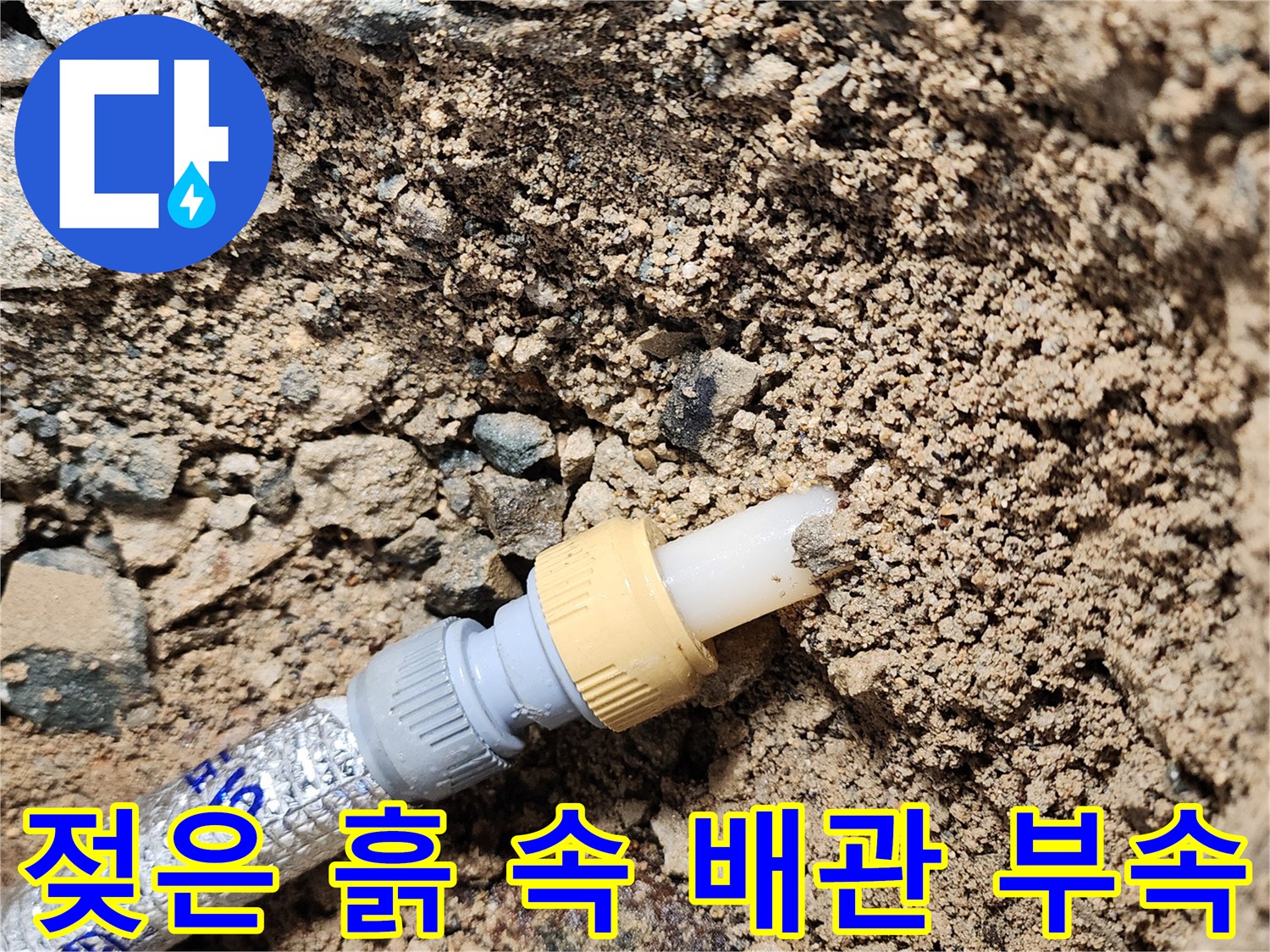 배관 연결 커넥터와 주변의 젖은 흙 상태를 근접 촬영한 이미지