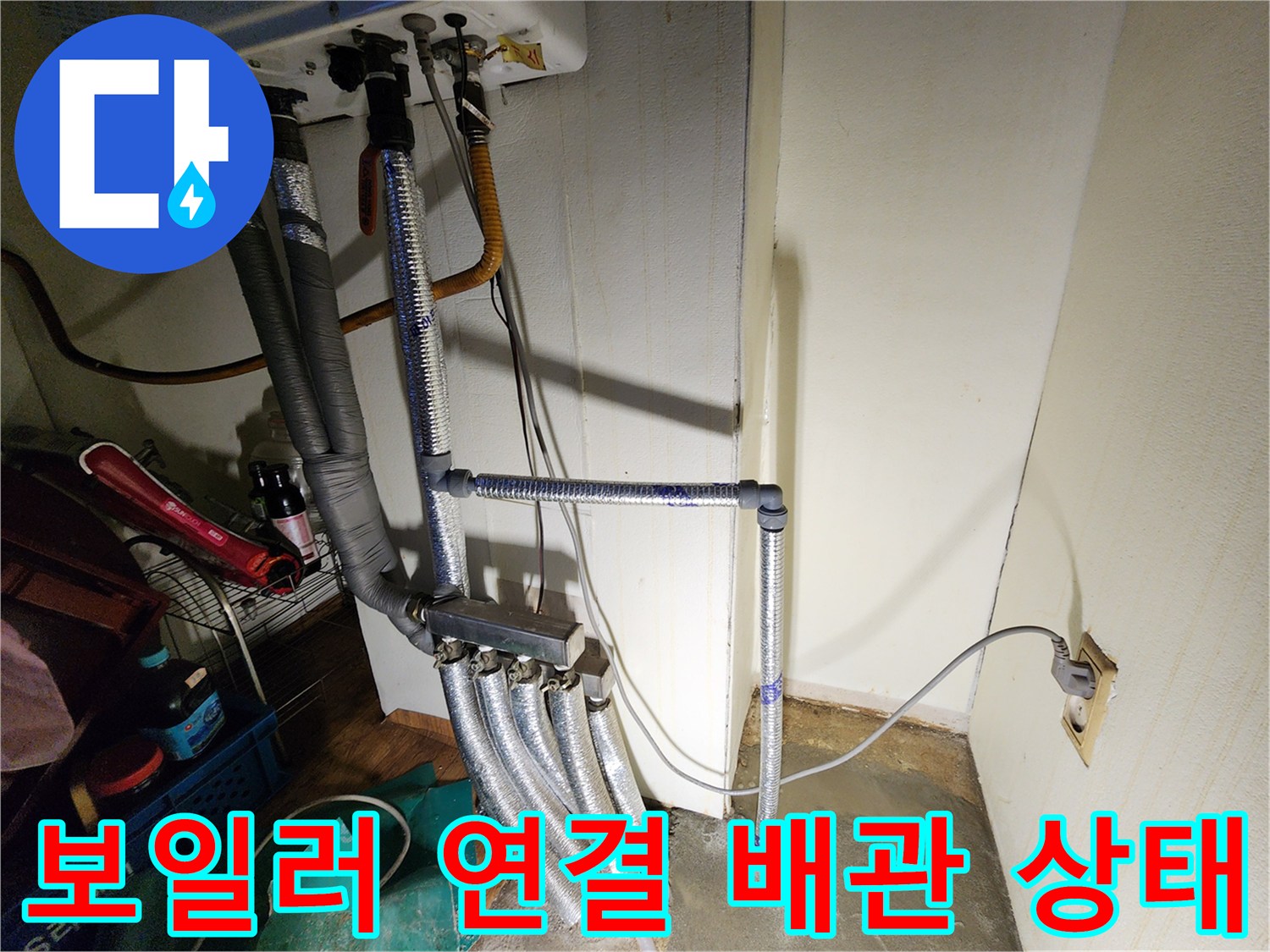 보일러 아래쪽 은색 배관과 전기선이 복잡하게 얽힌 모습