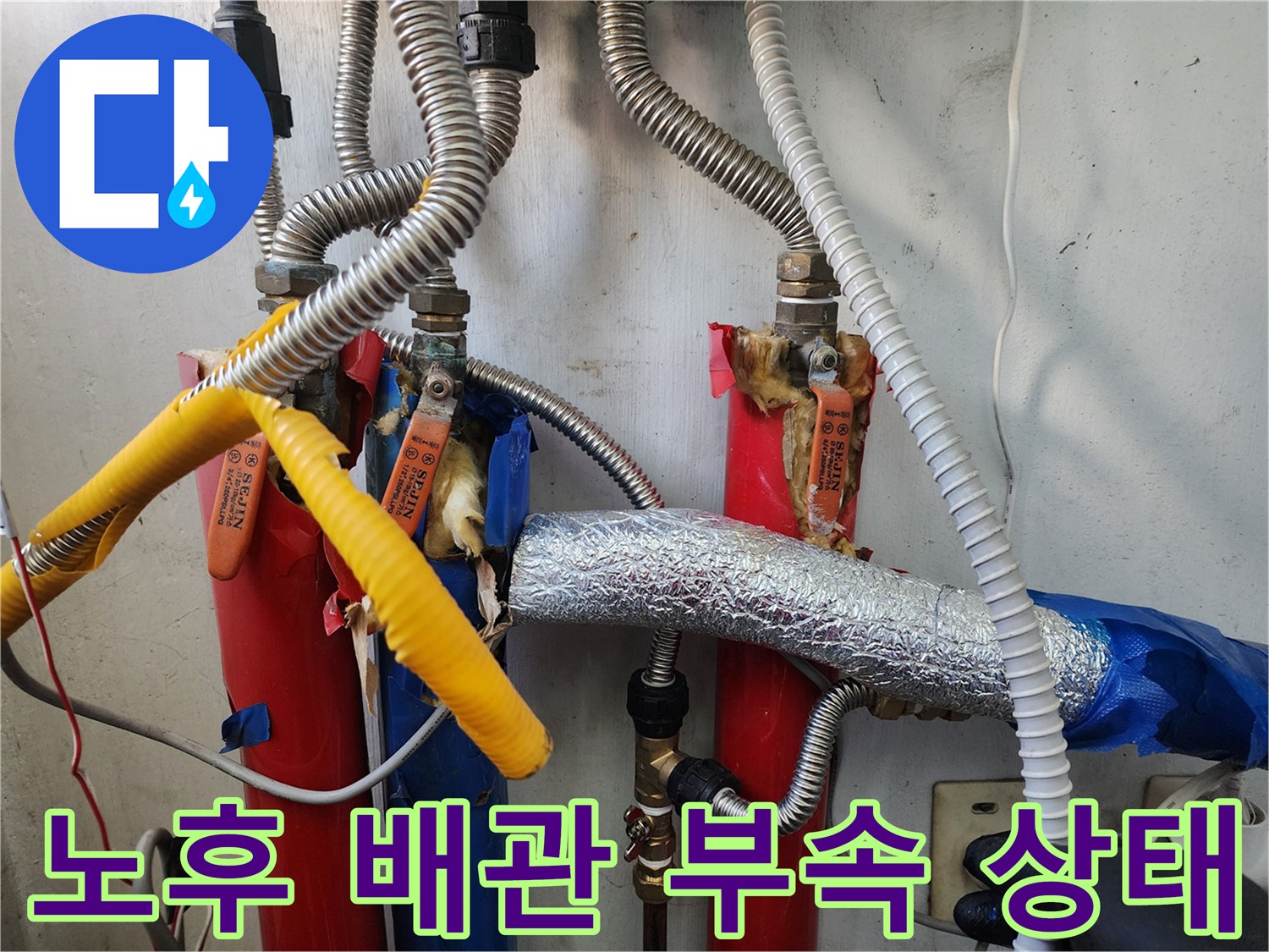 세탁실 배관-은색 보온재와 노란색 절연 테이프가 감긴 수도 배관