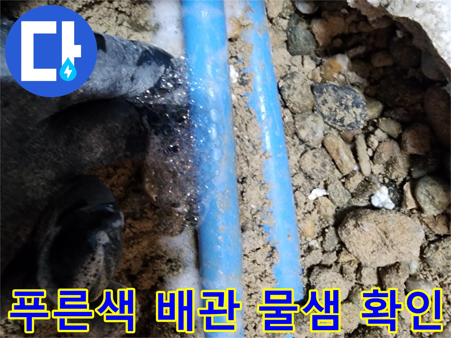 자갈과 흙 사이에서 누수가 진행 중인 푸른색 배관-배관 보수 작업
